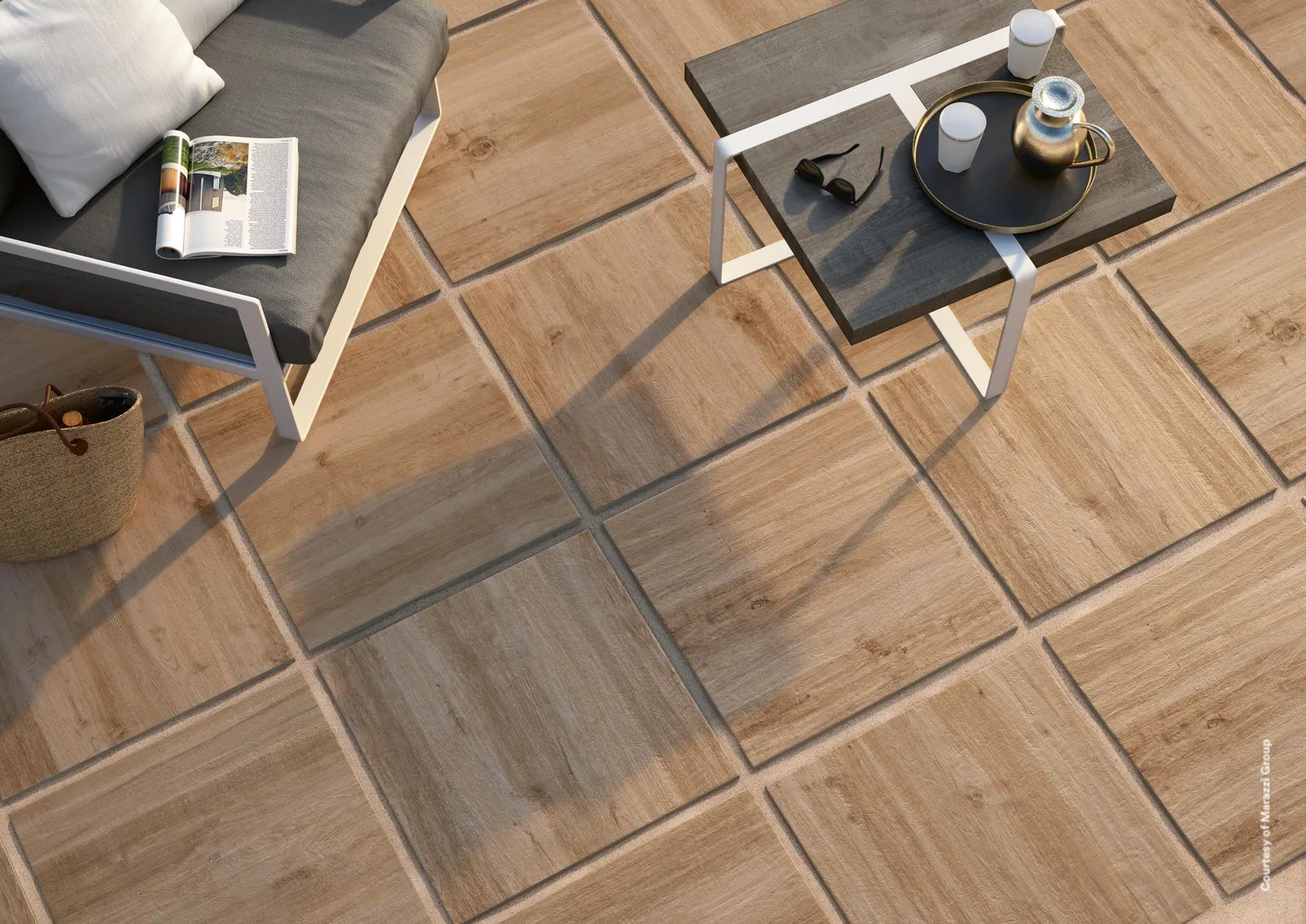 Marazzi Treverkhome20 Rovere: Terrasse mit Holzoptik-Platten 60x60 cm, Liege mit grauen Kissen und niedriger Beistelltisch