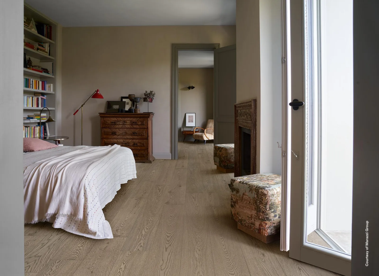 Schlafzimmer mit Bett, Bücherregal und Kommode, Boden durchgehend in mittelbraunen Holzoptik-Planken verlegt.
