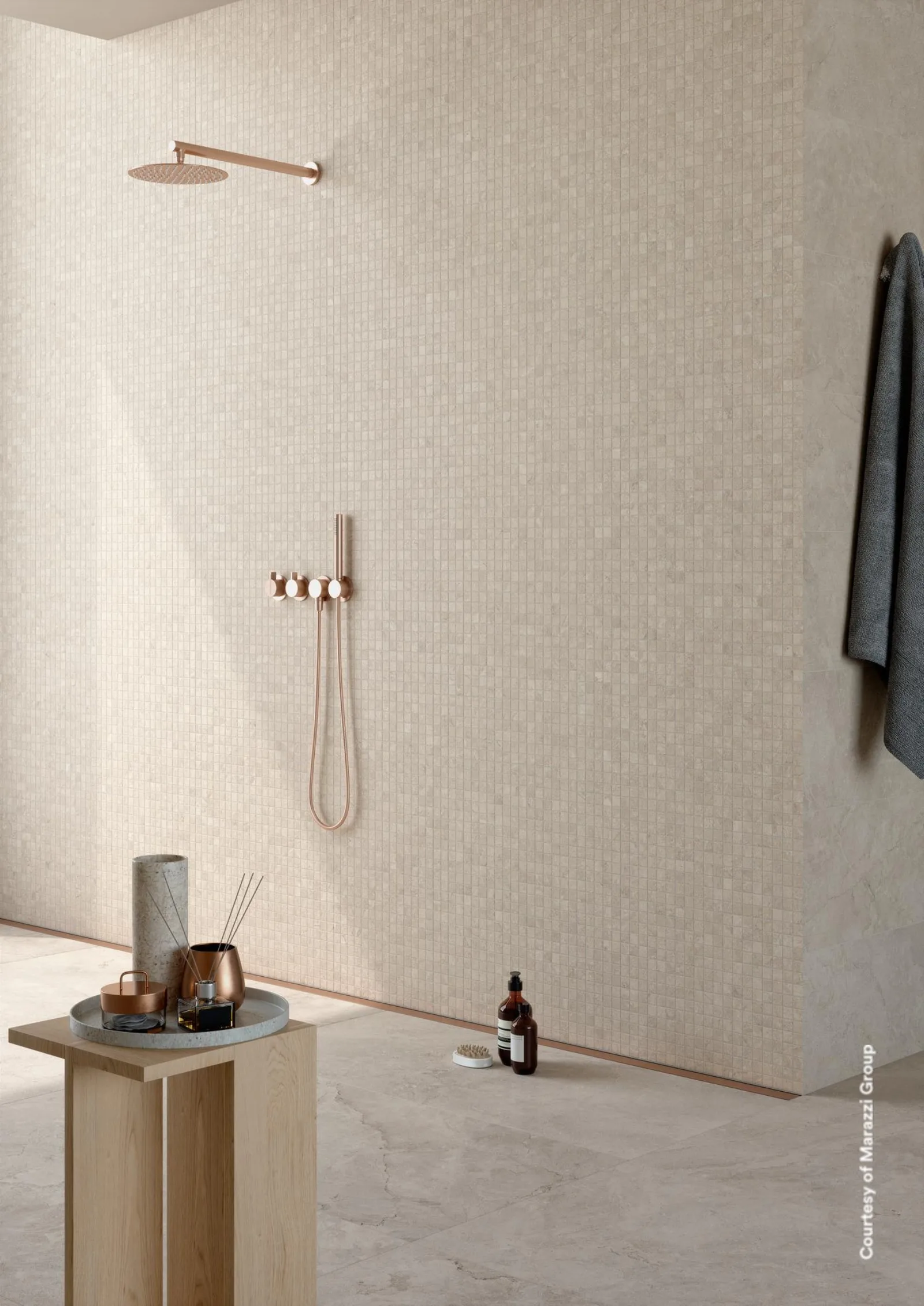 Duschbereich mit Regenbrause und Handbrause an cremefarbener Wand, Handtuch auf schwarzer Stange