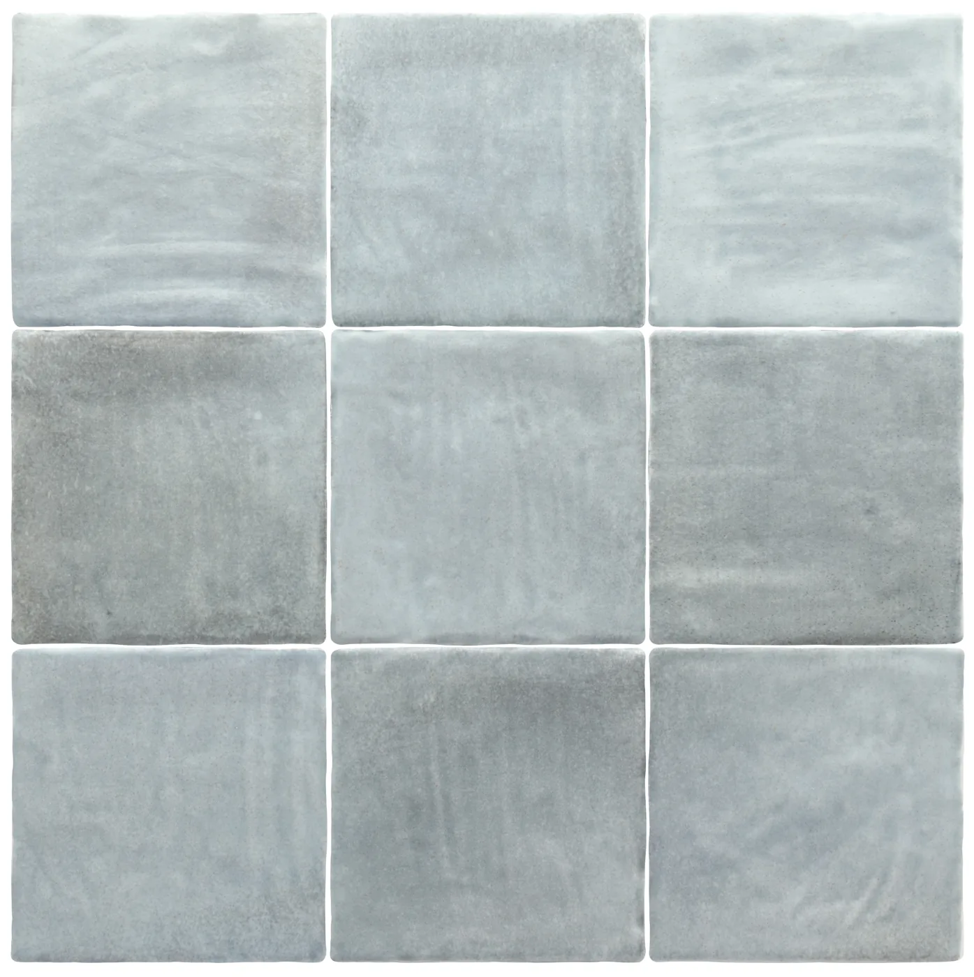 Sanft graublaue Steingut-Wandfliesen im Format 10×10 cm im Raster verlegt, matte Oberfläche mit wolkigen Farbnuancen.