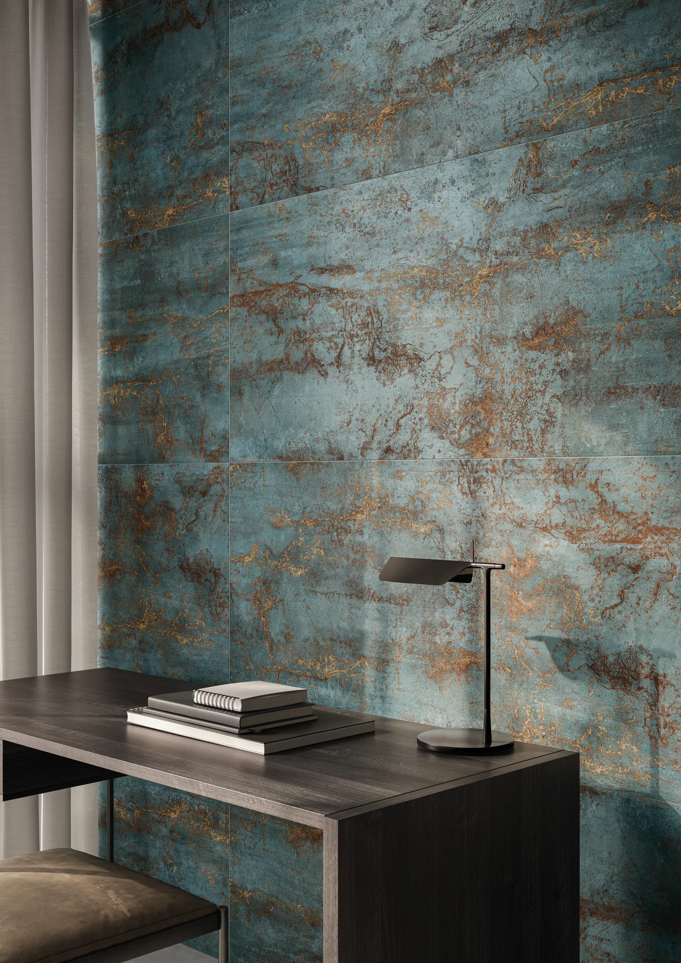 Schreibtisch vor einer petrolfarbenen Metalloptik-Wand mit kupferfarbenen Adern, Fliesenformat 60×120 cm.