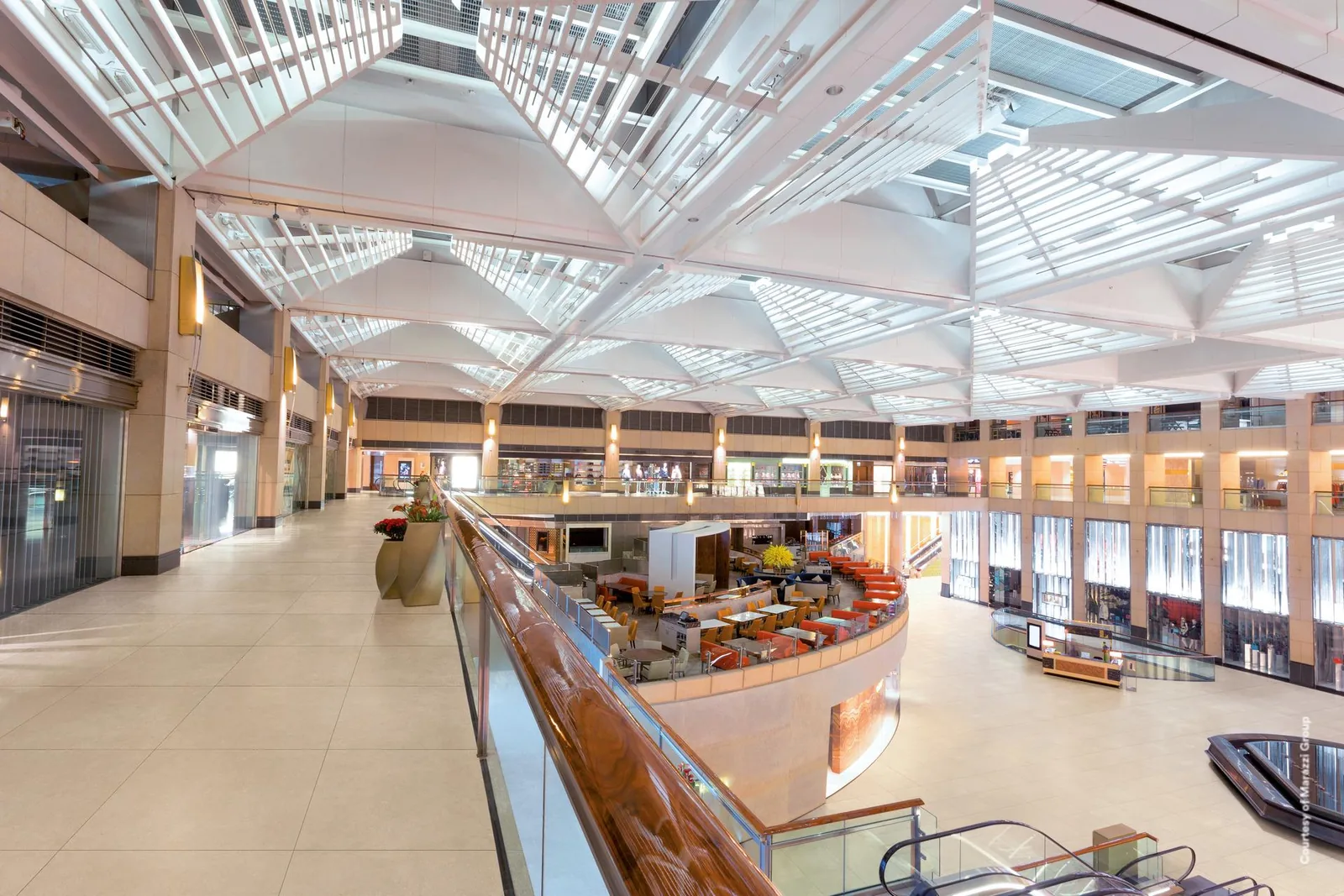 Einkaufszentrum mit Glasdach, Galerie und Food-Court, großflächig verlegter beiger Steinoptik-Boden im Format 60x60 cm.