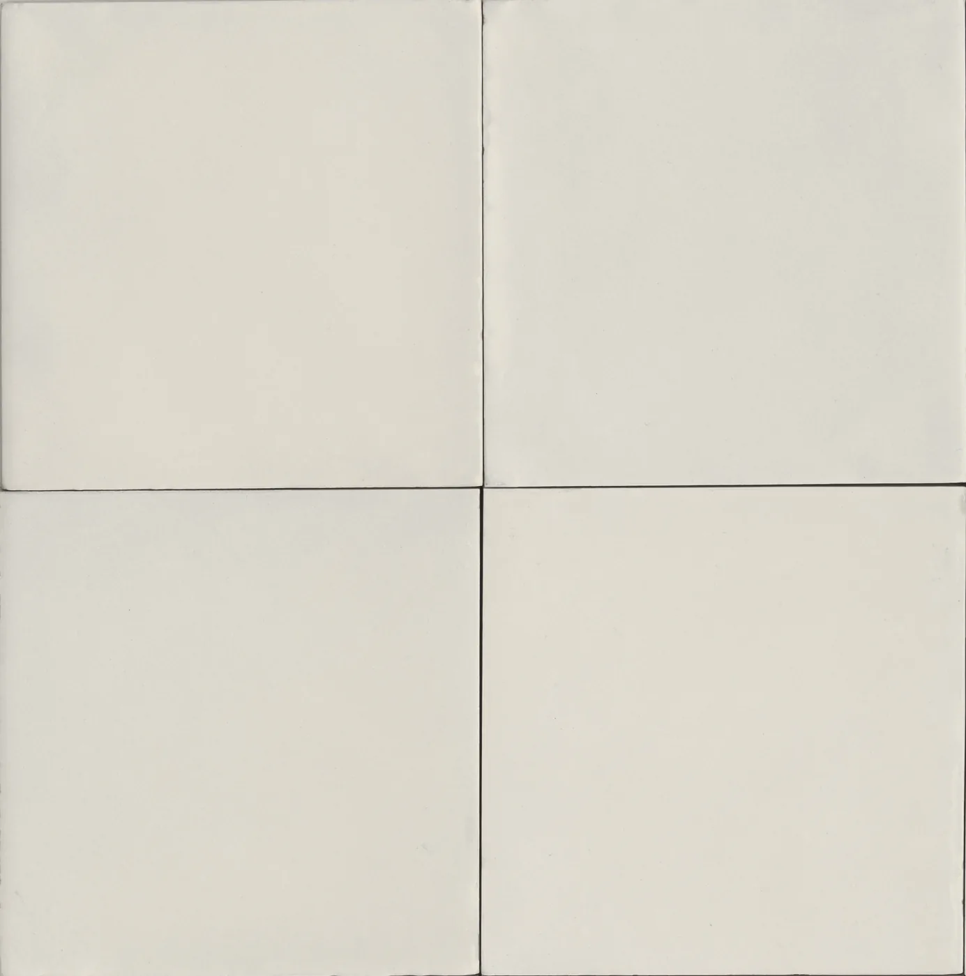 Vier einfarbige Fliesen 15x15 cm in warmem Weiß, seidenmatt, mit leicht unregelmäßigen Kanten und feinen Fugen.