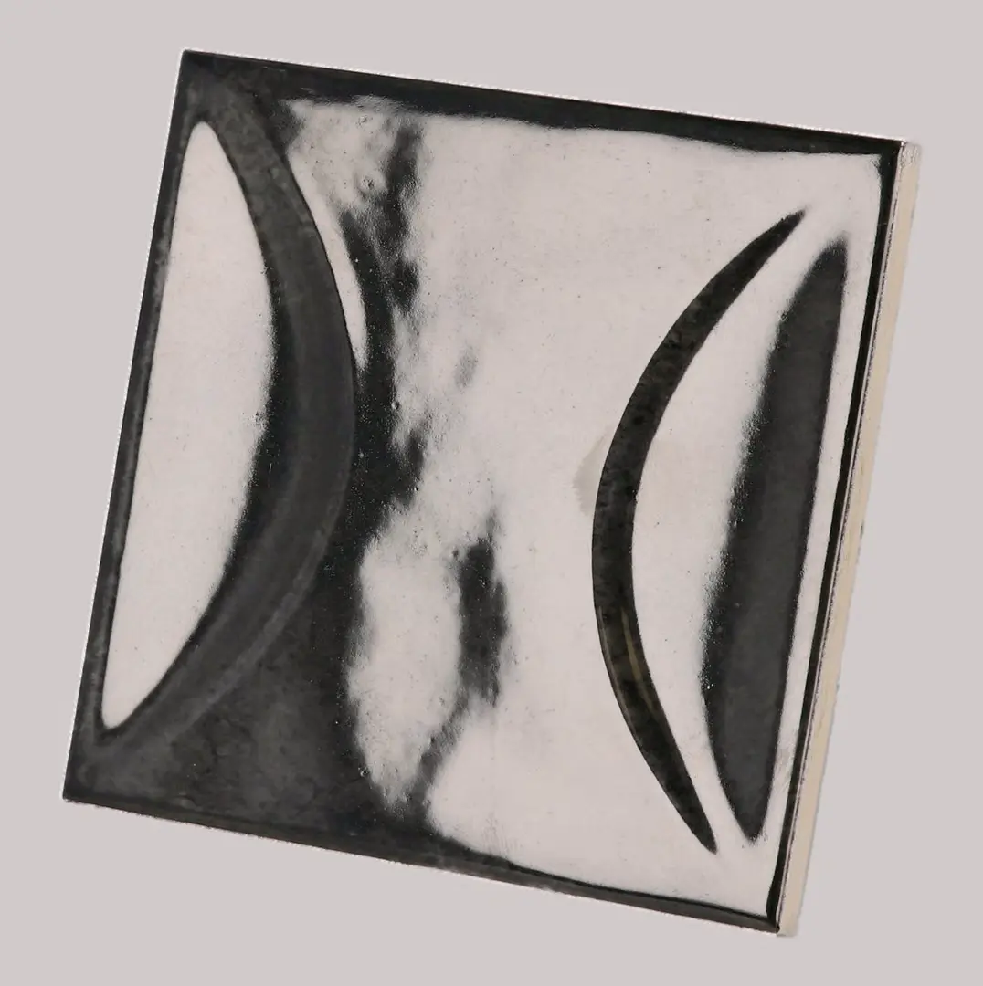 Hanoi Wandfliese in Black Ash Glasur, Format 10x10 cm, schräge Studio Aufnahme mit sichtbarem Glasurglanz.