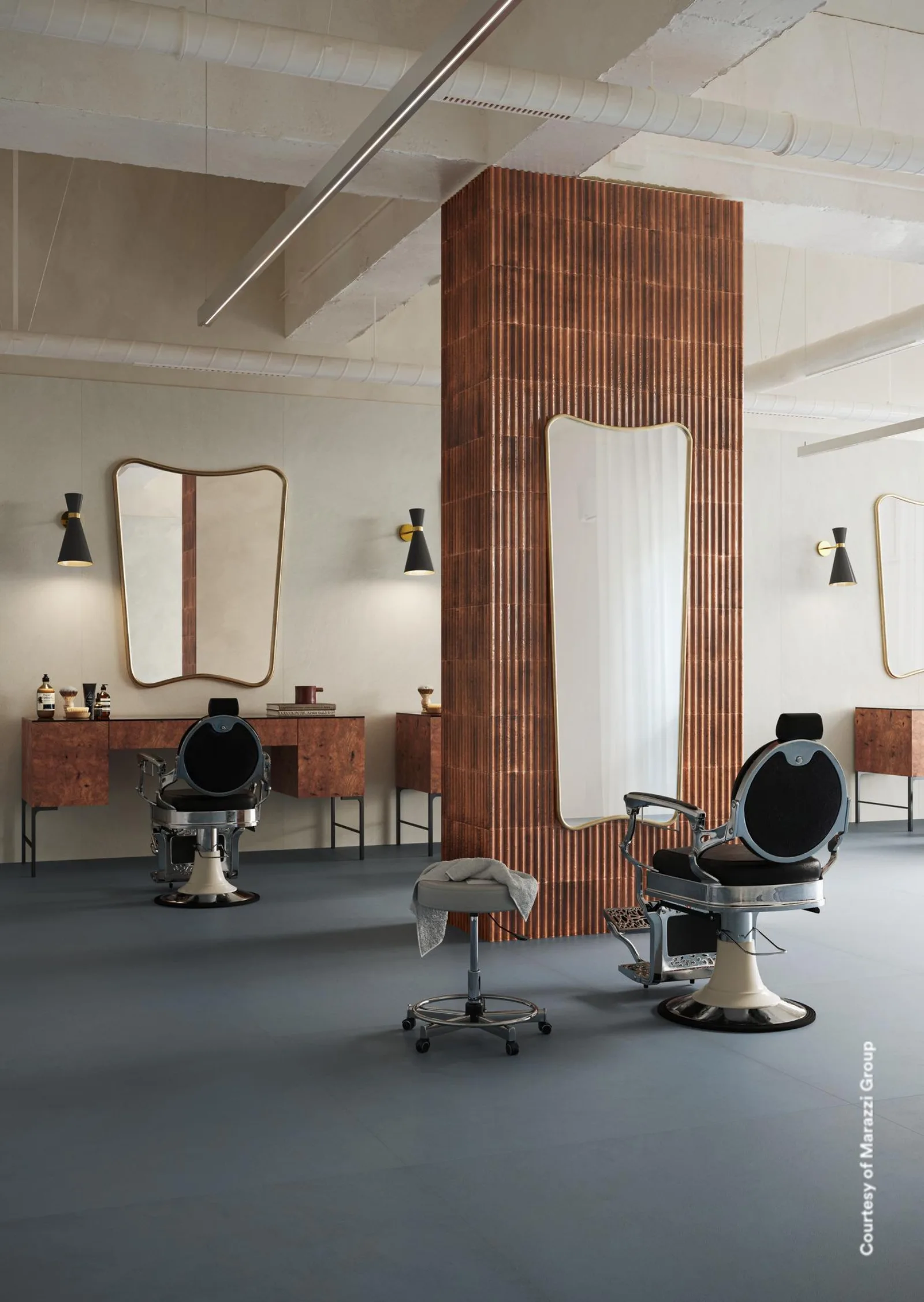 Salon mit blaugrauem Großformatboden, geriffelter Terrakotta-Säule, Spiegeln und zwei Stühlen