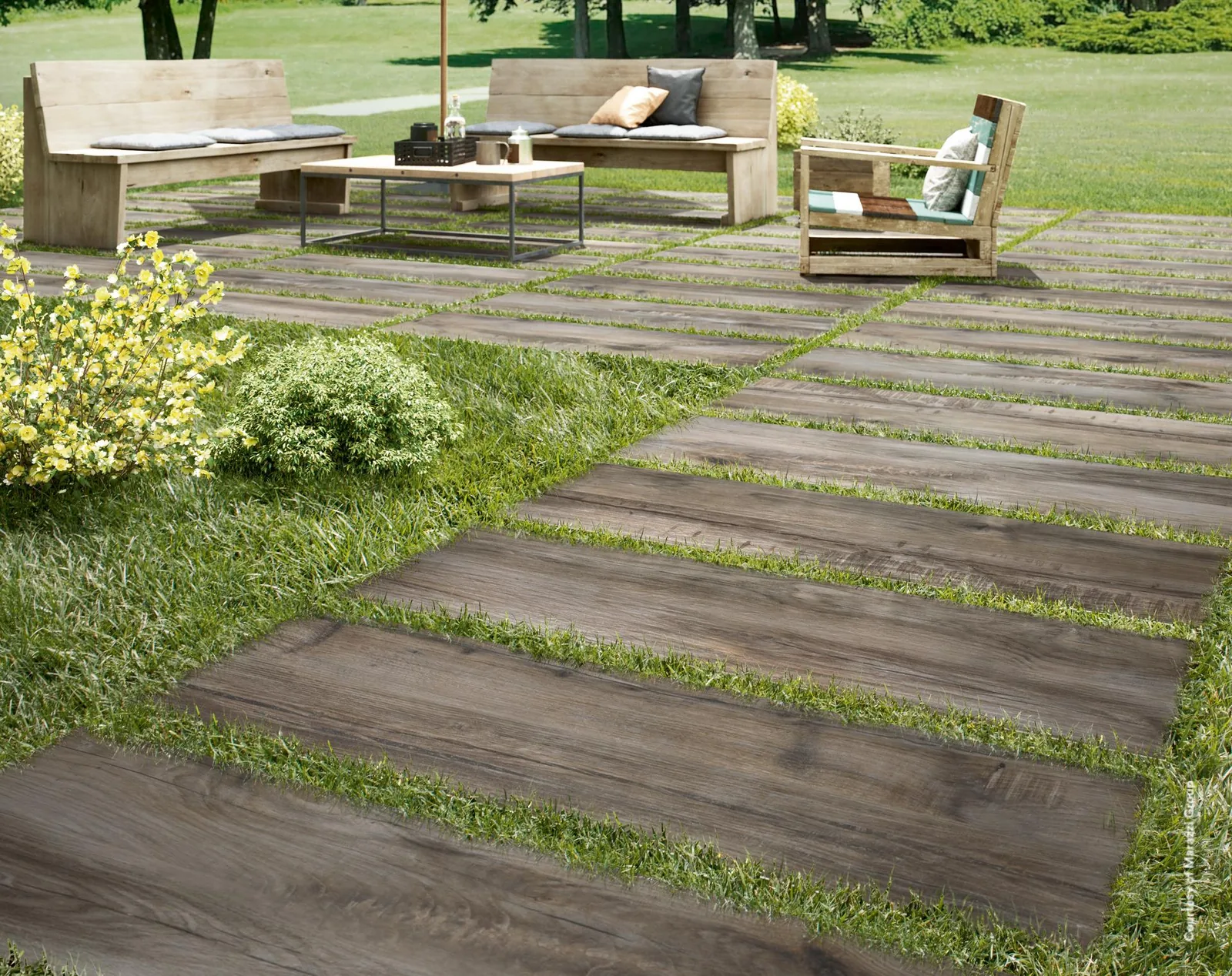 Gartenweg aus Treverkmade20 Fume 40x120 Holzoptik-Platten im Rasen, führt zu einer Sitzgruppe mit Holzbänken