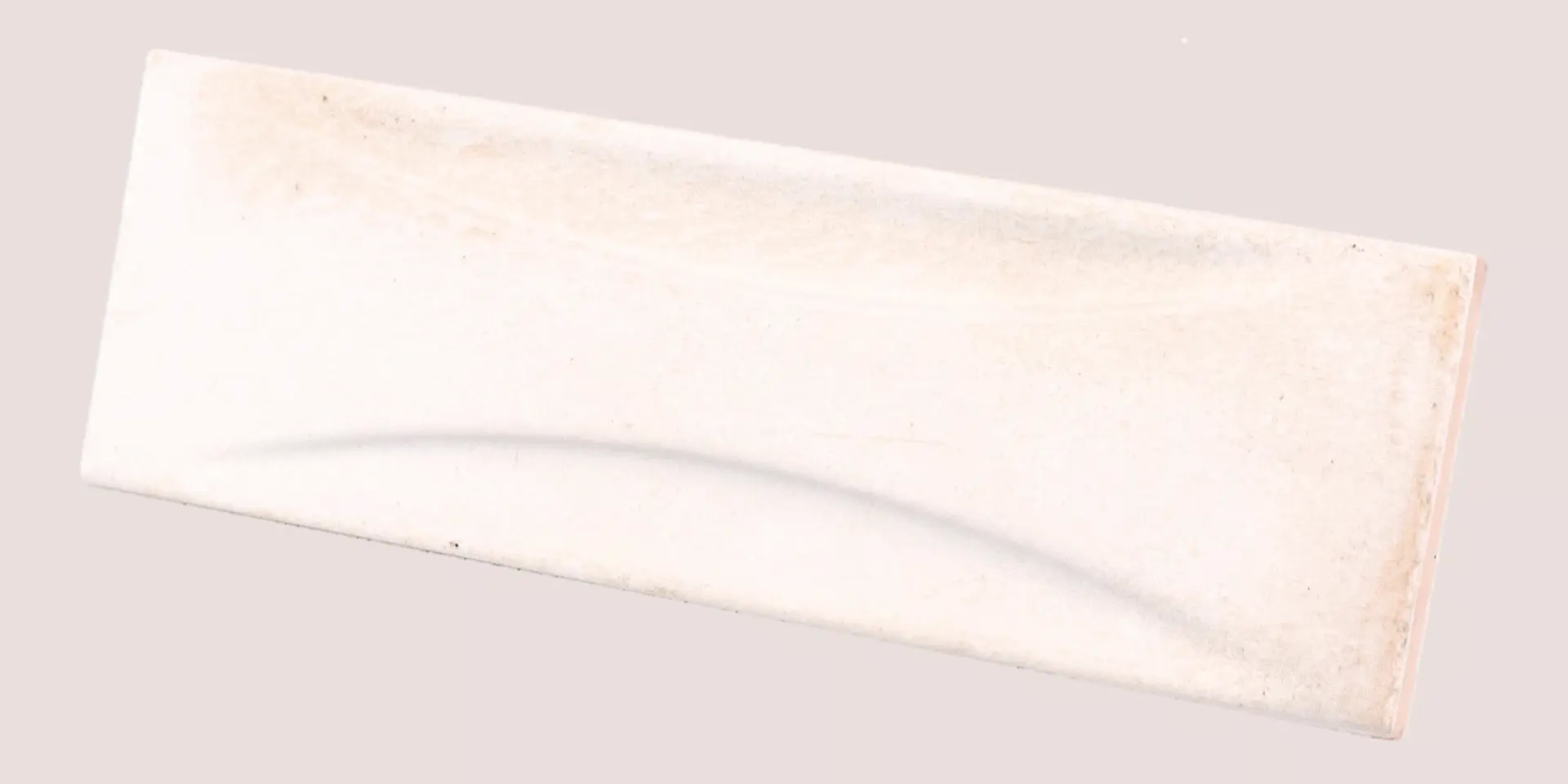 Hanoi Wandfliese in White Glasur, Format 6,5x20 cm, schräge Studio Aufnahme mit sichtbarem Glasurglanz.