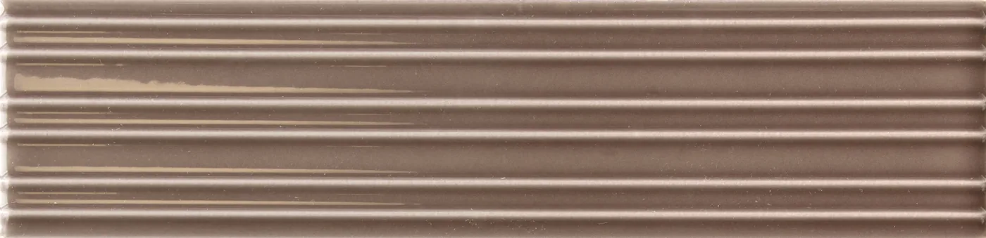 Rechteckige Wandfliese in dunklem Nussbraun, glänzend, mit parallelem Rillenrelief, im Format 6x24,6 cm.