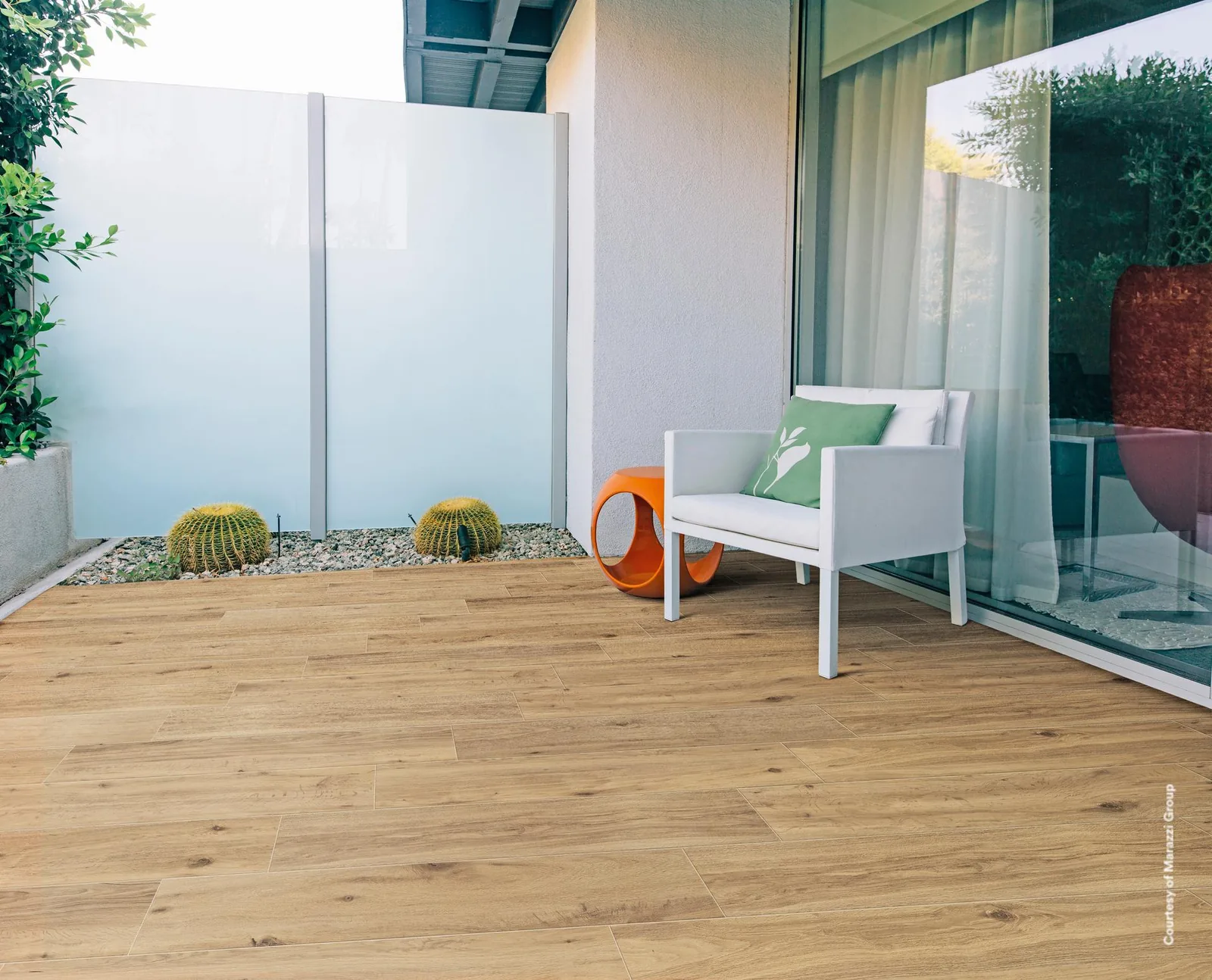 Innenhof mit weißem Sessel, Kakteen und Sichtschutz aus Glas, Boden in Holzoptik Miele 20x120 cm
