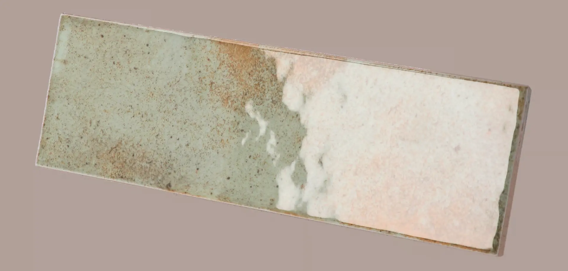 Hanoi Wandfliese in Celadon Glasur, Format 6,5x20 cm, schräge Studio Aufnahme mit sichtbarem Glasurglanz.