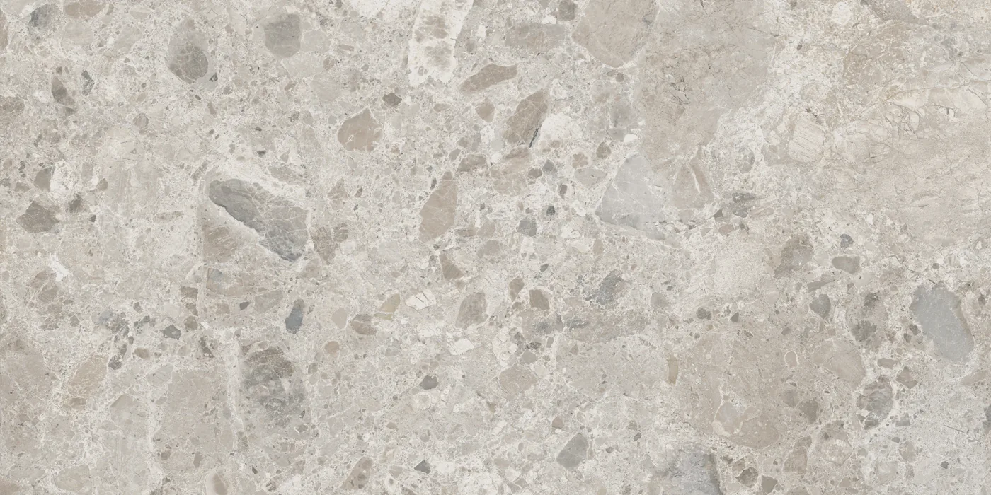 Graue Fliese 60×120 cm in Terrazzo-Optik mit hellen und dunkelgrauen Steinsplittern unterschiedlicher Größe.