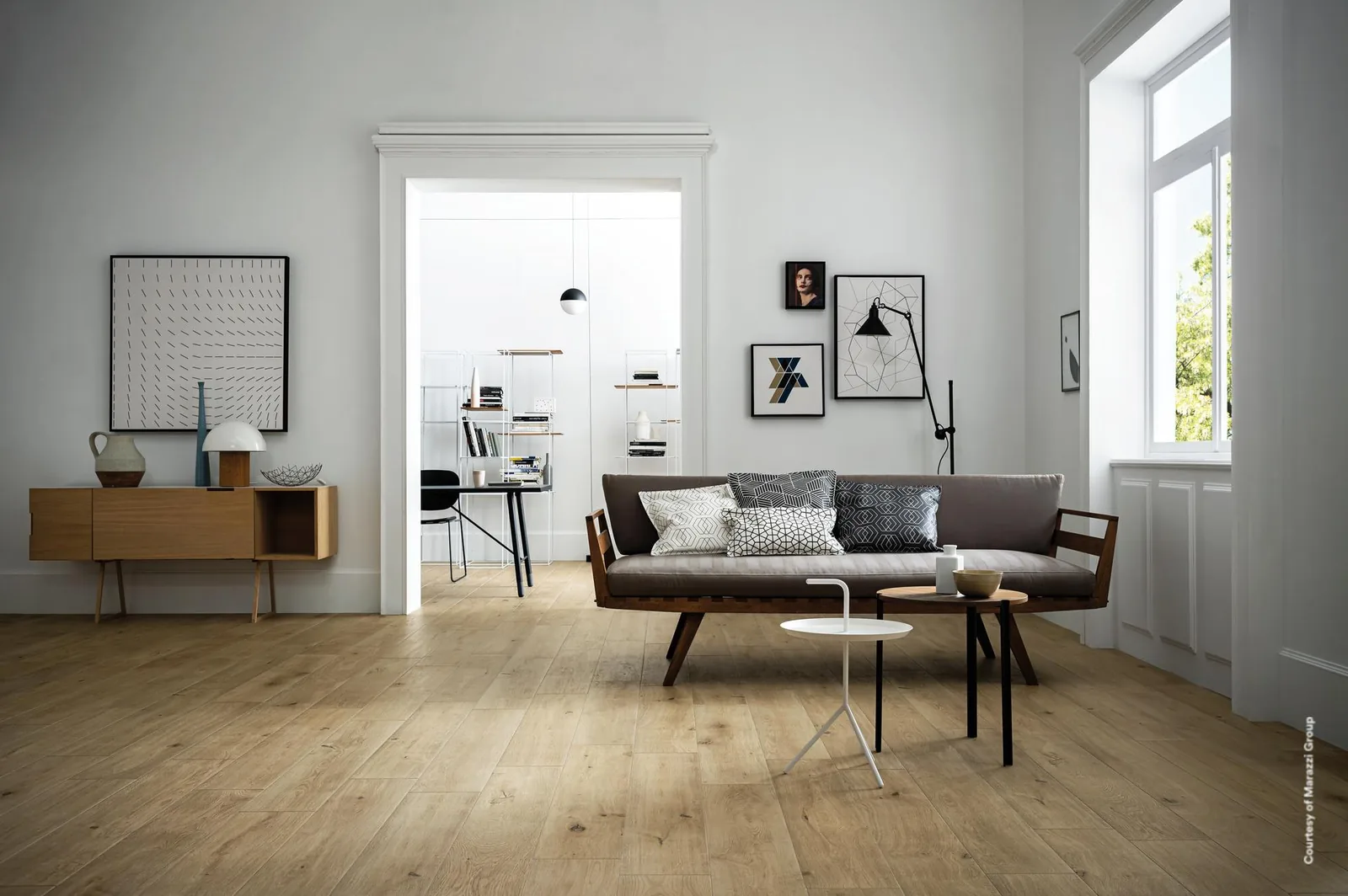 Heller Wohnraum mit grauem Sofa, Holz-Sideboard und Durchgang, Boden aus naturbeigen Holzoptik-Dielen im Längsformat.