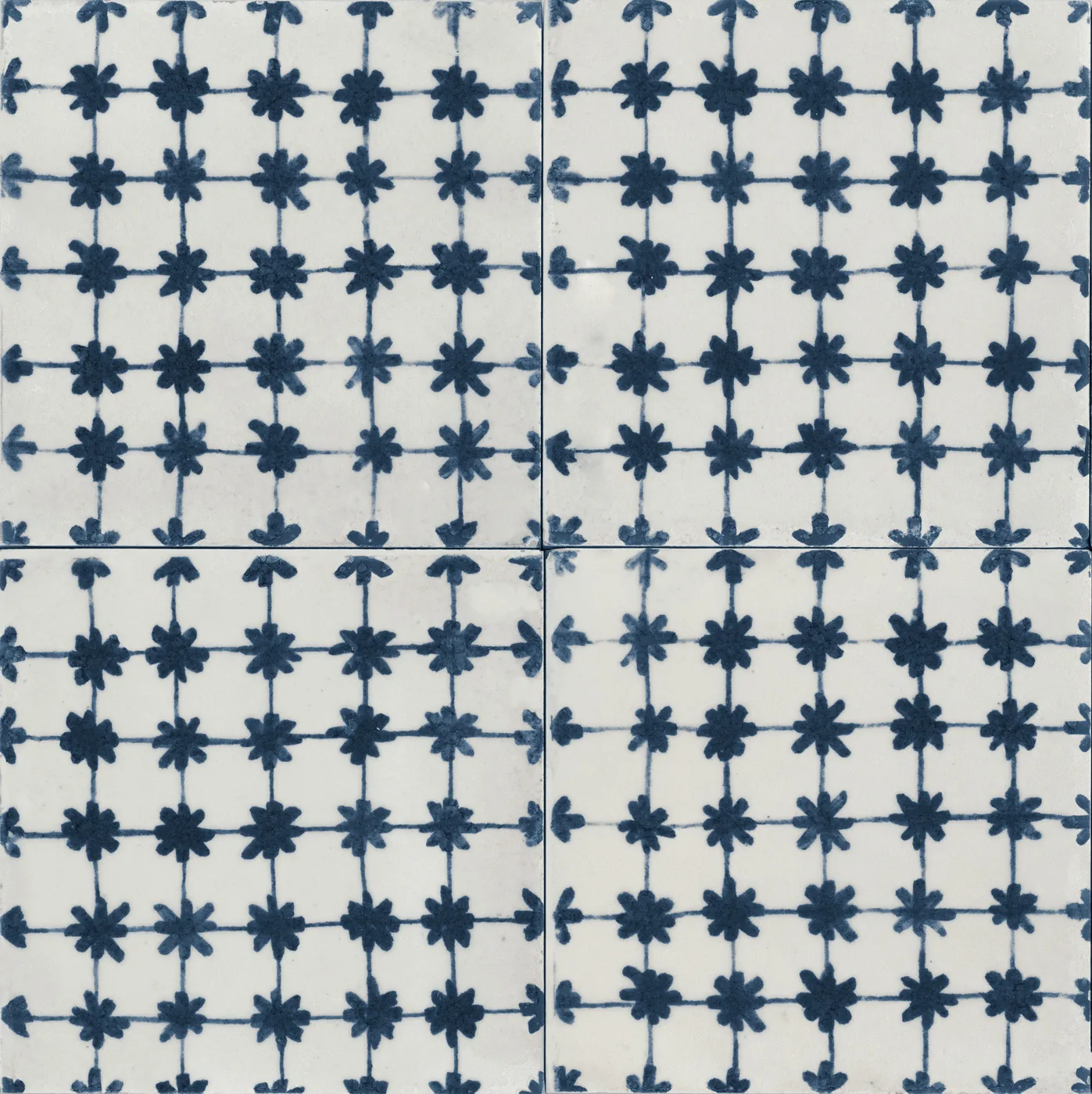 Vier glänzende Fliesen 15x15 cm mit Raster aus kleinen dunkelblauen Blütensternen und feinen Linien auf weißem Grund.