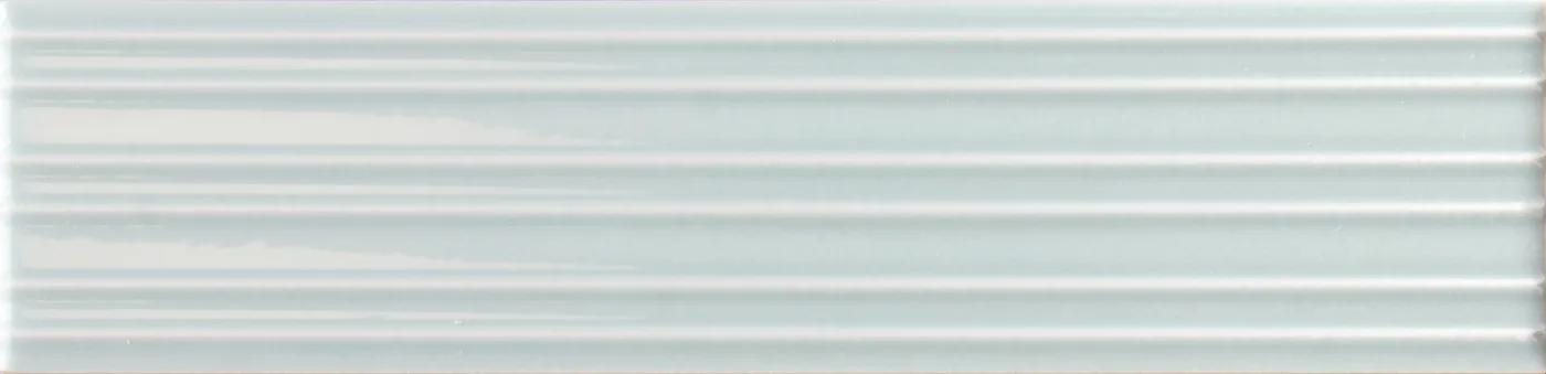 Rechteckige Wandfliese in zartem Eisblau, glänzend, mit parallelem Rillenrelief, im Format 6x24,6 cm.