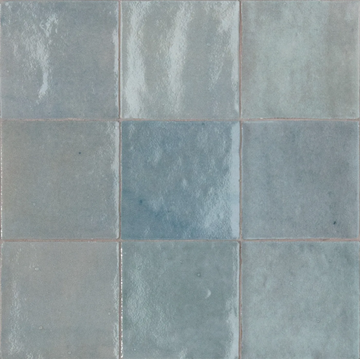 Glänzende Wandfliesen 10x10 cm in hellem Graublau, einzelne Fliesen heller oder kräftiger blau