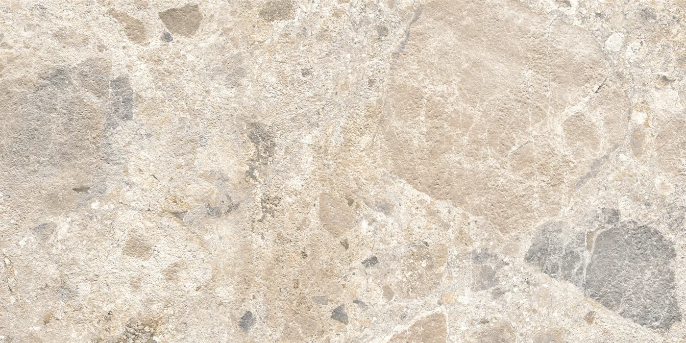 Cremefarbene Fliese 30×60 cm in Terrazzo-Optik mit beigen, grauen und braunen Steinsplittern unterschiedlicher Größe.
