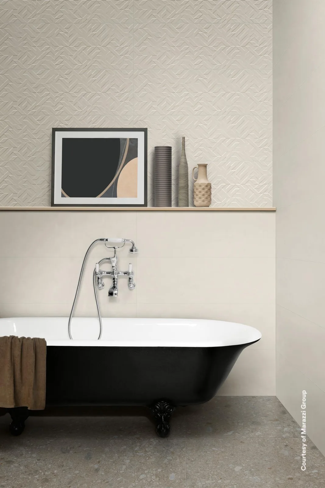 Bad mit schwarzer freistehender Wanne vor weißer Wand, oben weißes Relief mit geometrischen Linien und ein Wandbord.