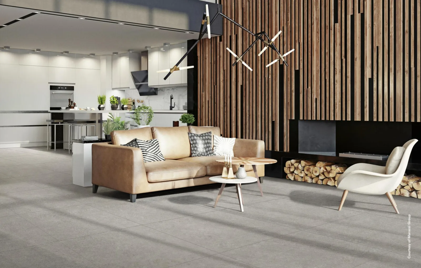 Offener Wohnraum mit grauer Steinoptik-Fliese im Großformat, Ledersofa, Holzlamellenwand und Küche im Hintergrund.