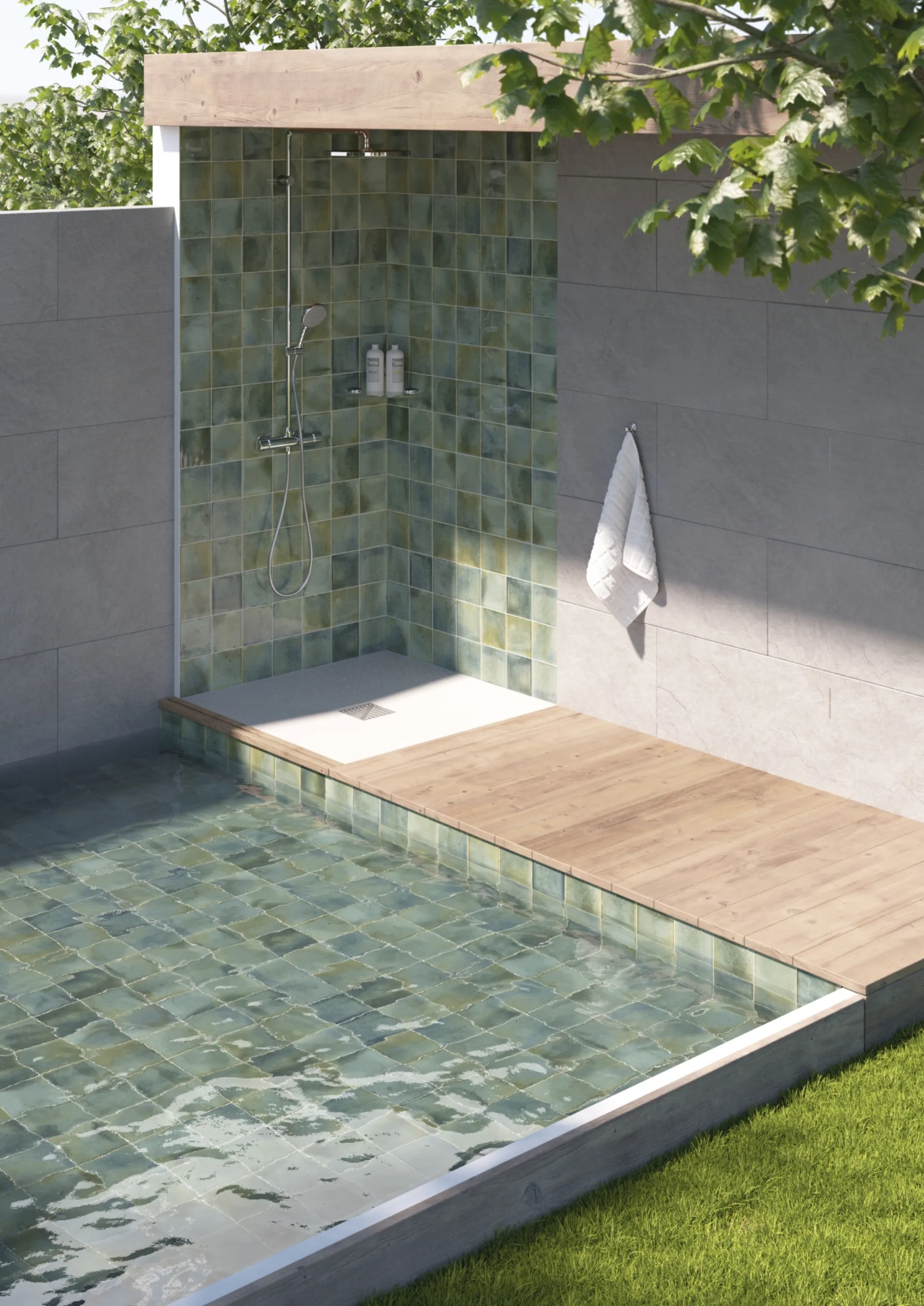 Grün gefliester Duschbereich am Pool mit Holzsteg und weißer Wand im hellen Sonnenlicht.