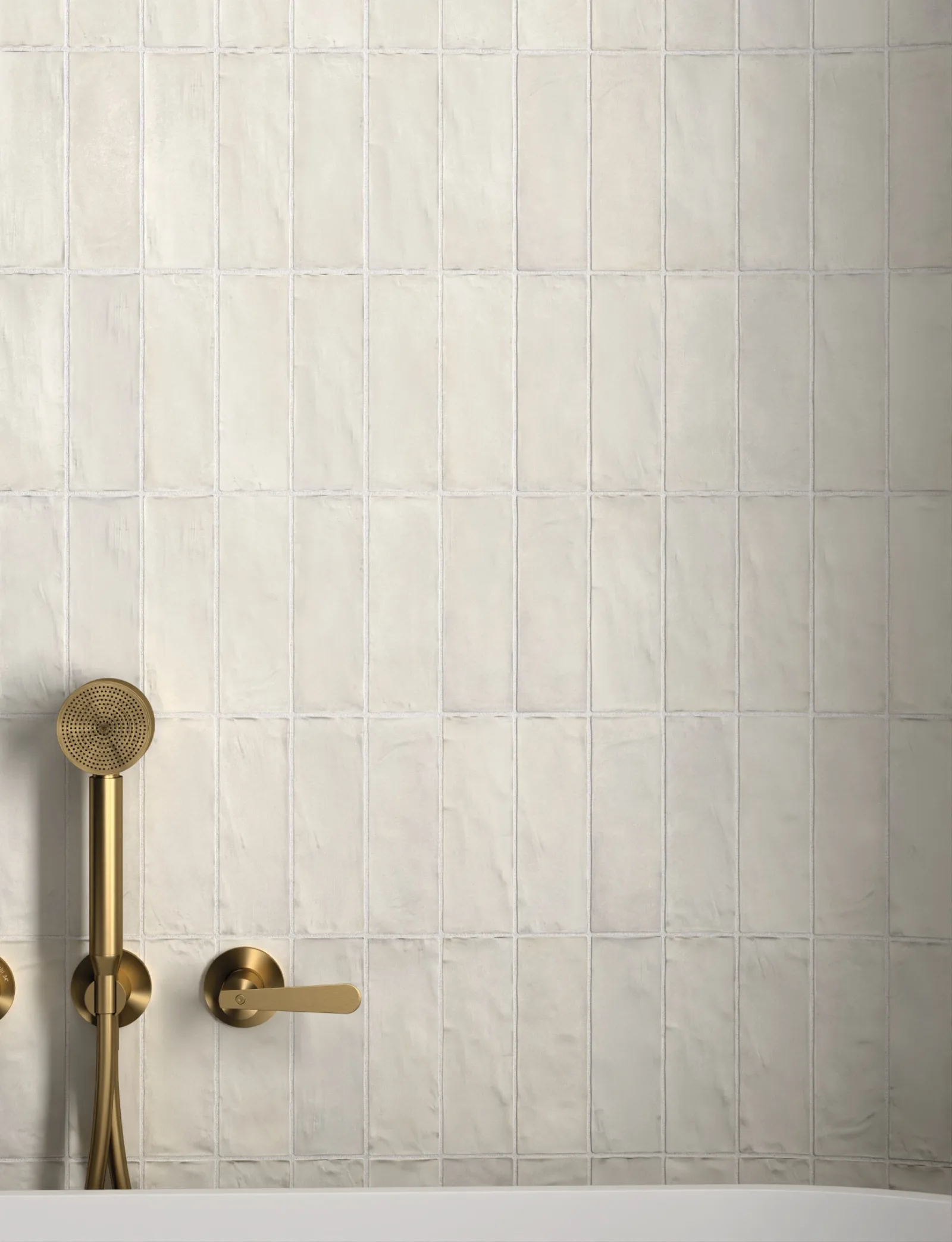 Dusche mit weißen Riemchen Equipe Sabbia Silica White 6,5x20 cm im Stapelverband und gebürsteter Messingarmatur.