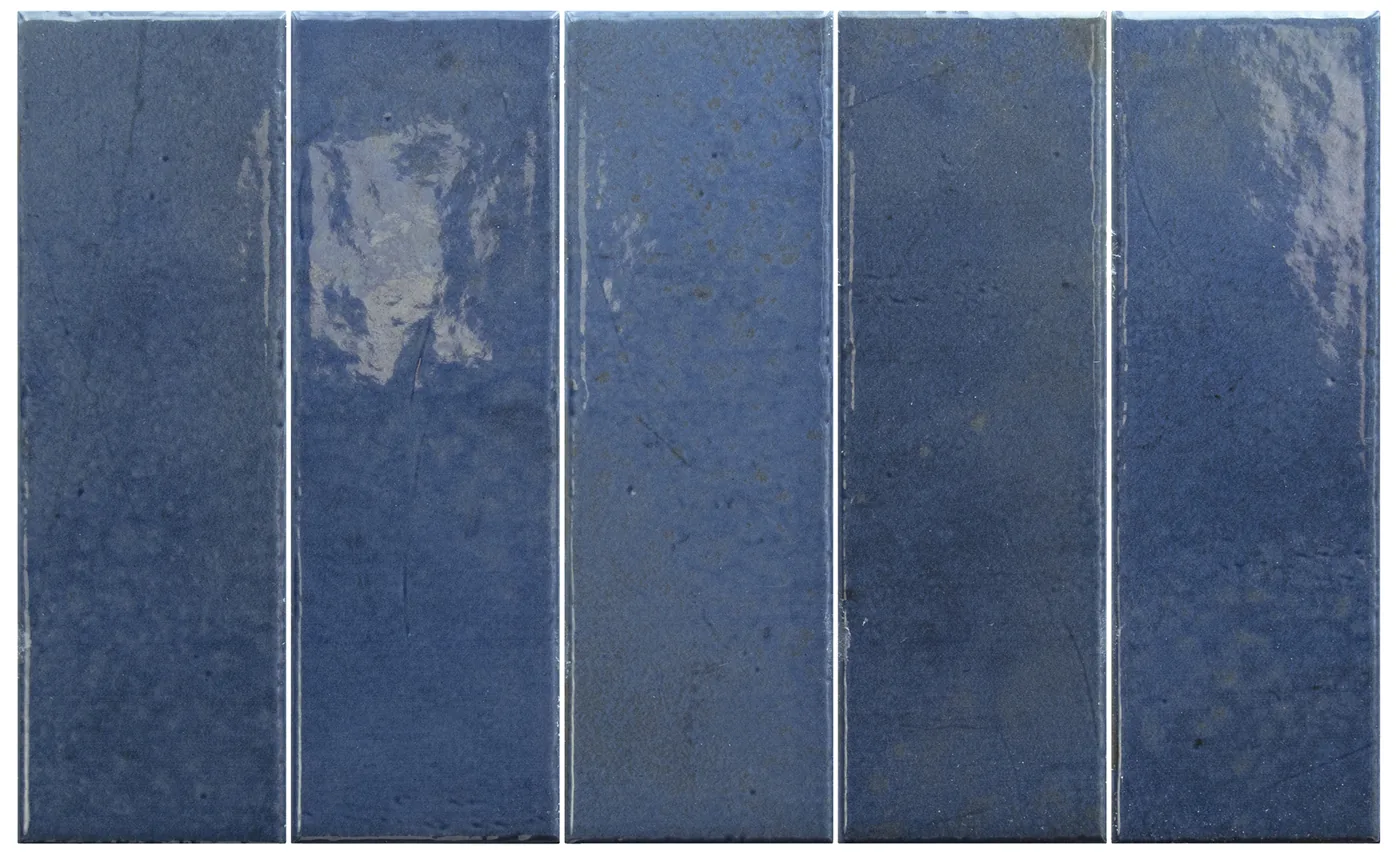 Kräftig dunkelblaue längliche Riegelfliesen 6x18,6 cm, senkrecht verlegt, glänzend mit leichtem Relief und Farbnuancierung.