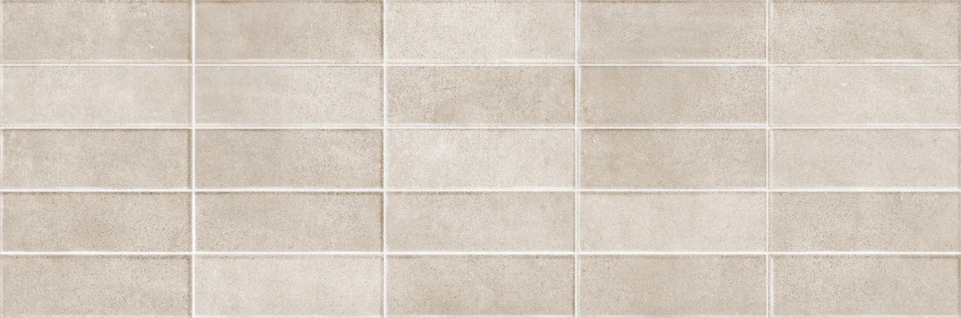 Graubeige Wandfliese 25×76 cm mit reliefartigem Raster aus versetzten, leicht erhabenen Rechtecken.