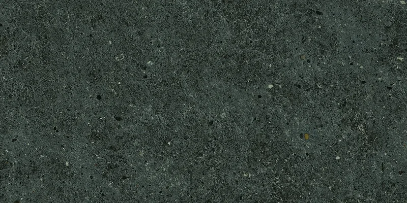 Dunkelgraue Steinoptik mit feiner Sprenkelung, matter rauer Oberfläche und leichten Steinporen.