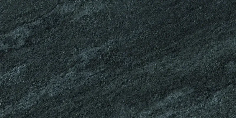 Nahaufnahme einer anthrazit-schwarzen Steinoberfläche mit feinen grauen Sprenkeln und dezenten Linien.