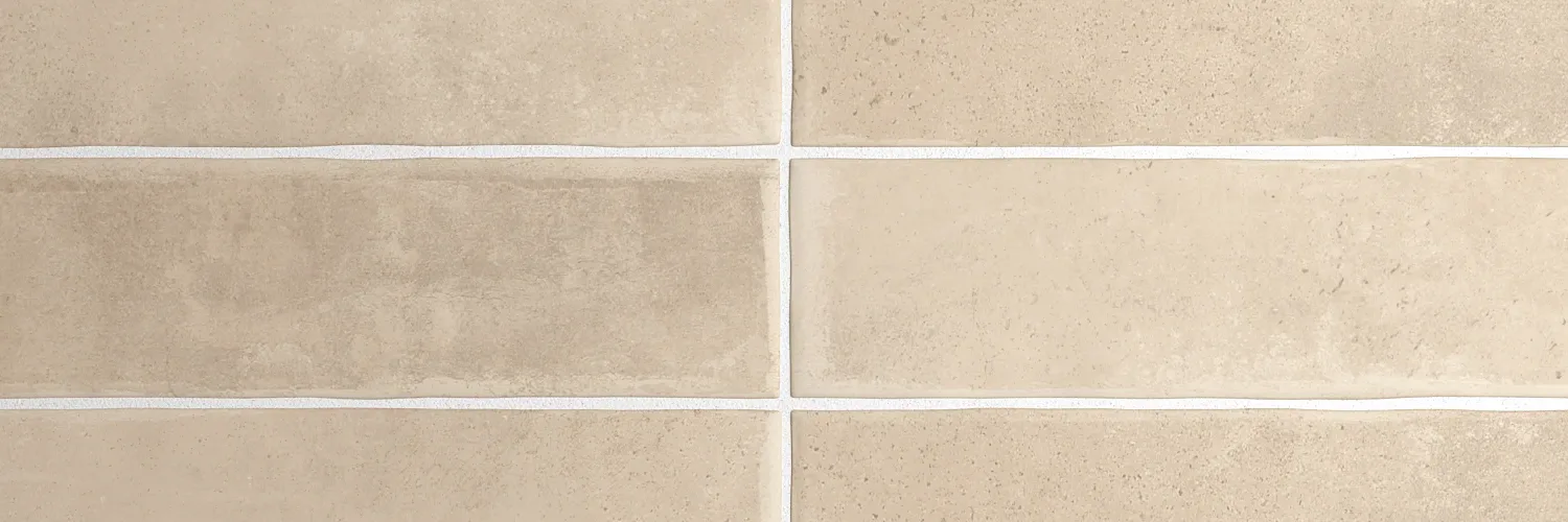 Nahaufnahme einer erdbraunen Wandfliese mit lebendiger Lehm-Maserung und mattem Finish.