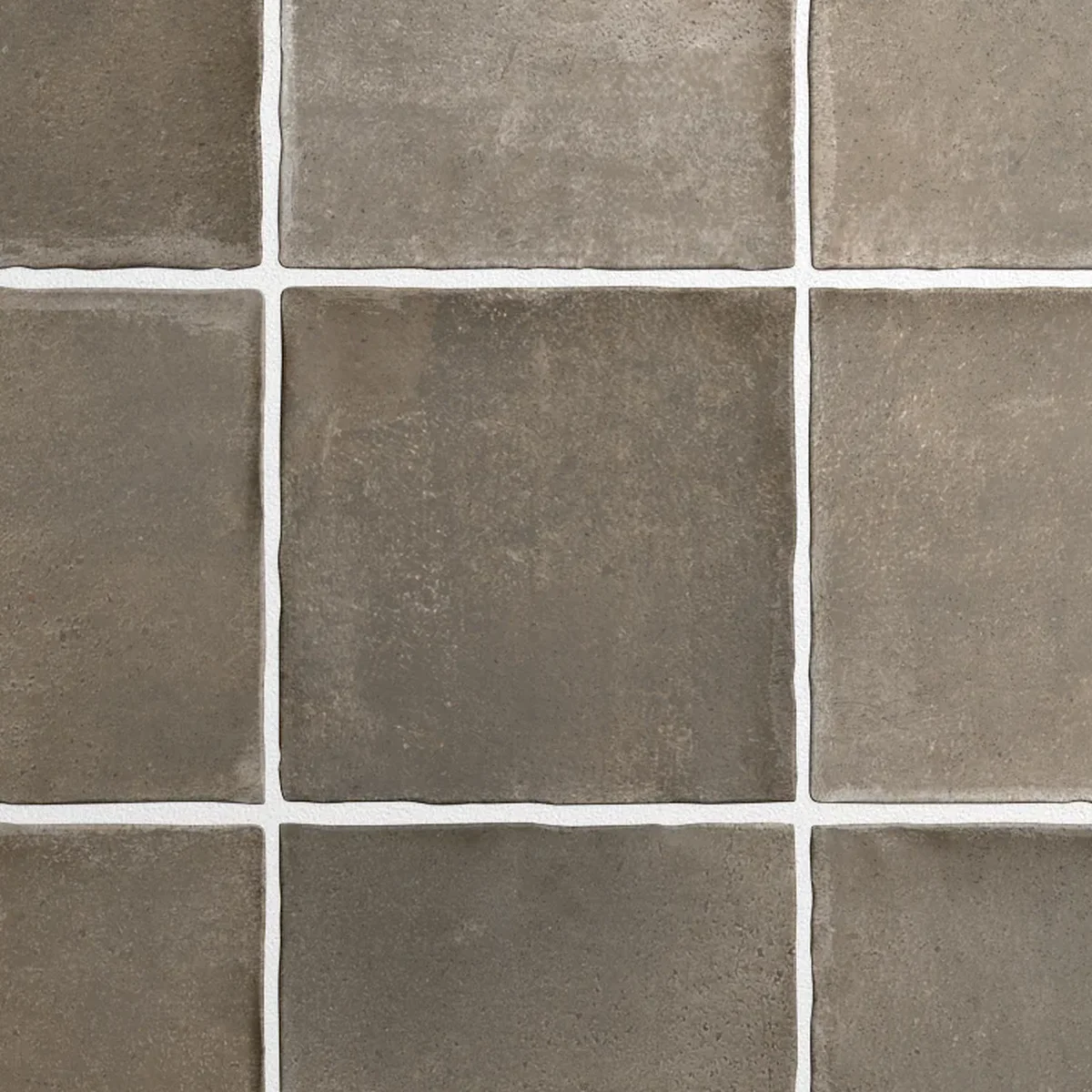 Nahaufnahme einer kakaobraune Wandfliese mit lebendiger Lehm-Maserung und mattem Finish.