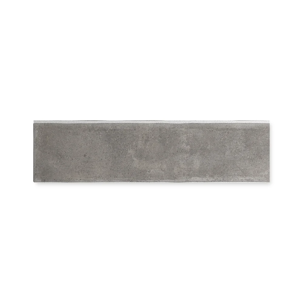 Einzelne mittelgraue Wandfliese 6×24,6 cm freigestellt auf weißem Hintergrund mit feiner Lehm-Maserung.