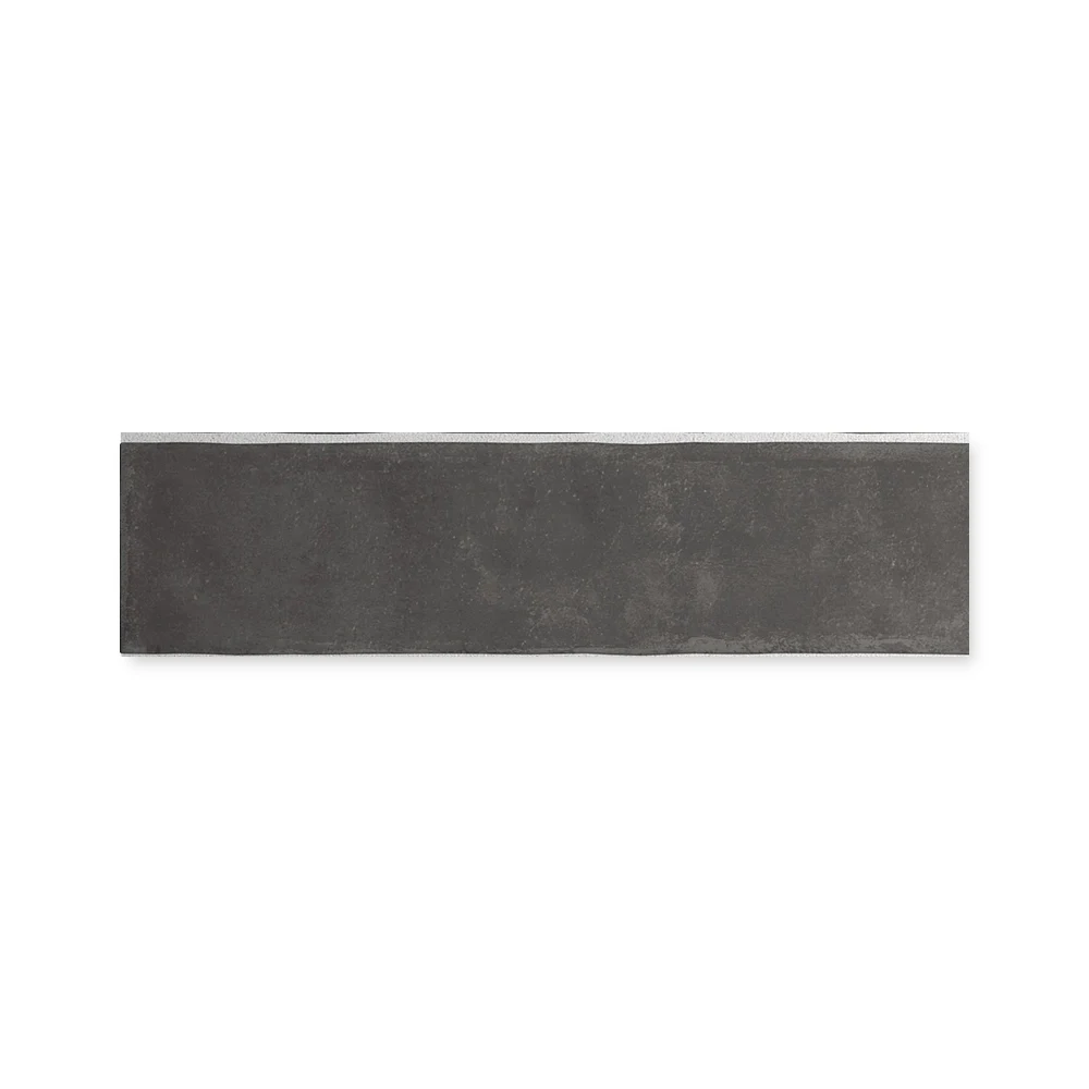 Einzelne schwarze Wandfliese 6×24,6 cm freigestellt auf weißem Hintergrund mit feiner Lehm-Maserung.