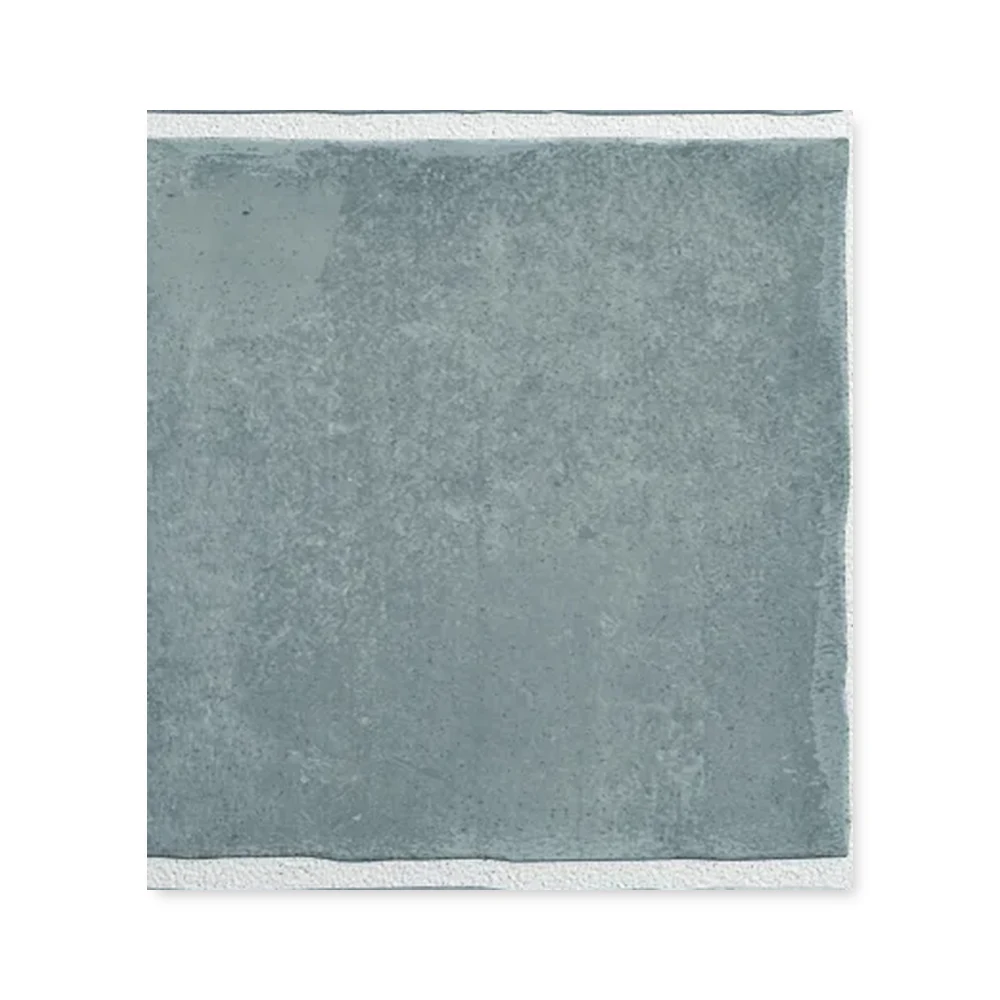 Einzelne cremegraue Wandfliese 10×10 cm freigestellt auf weißem Hintergrund mit feiner Lehm-Maserung.