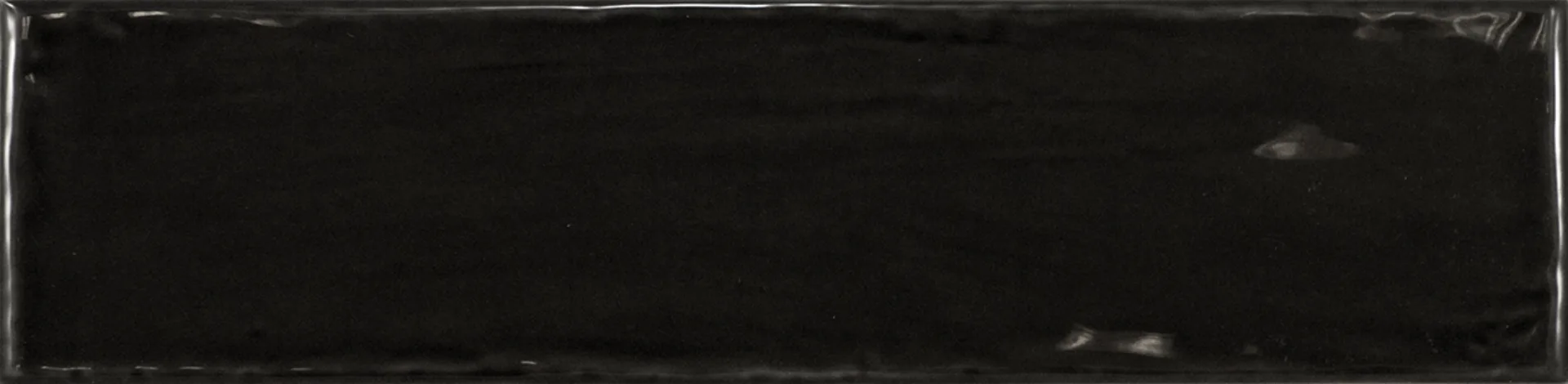 Einzelne schwarze Rechteckfliese mit glänzender Glasuroberfläche im Format 7,5×30 cm und sanften Lichtreflexen.