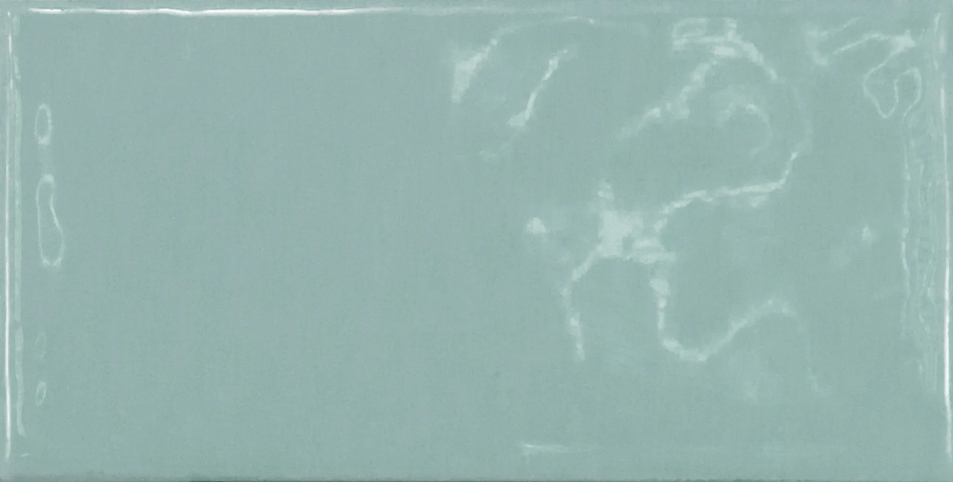 Einzelne jadegrüne Rechteckfliese mit glänzender Glasuroberfläche im Format 7,5×15 cm und sanften Lichtreflexen.