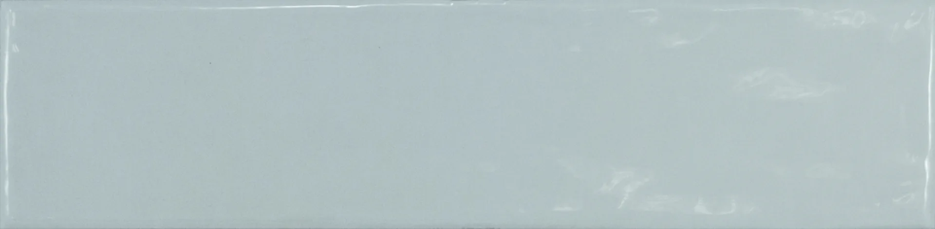 Einzelne graublaue Rechteckfliese mit glänzender Glasuroberfläche im Format 7,5×30 cm und sanften Lichtreflexen.