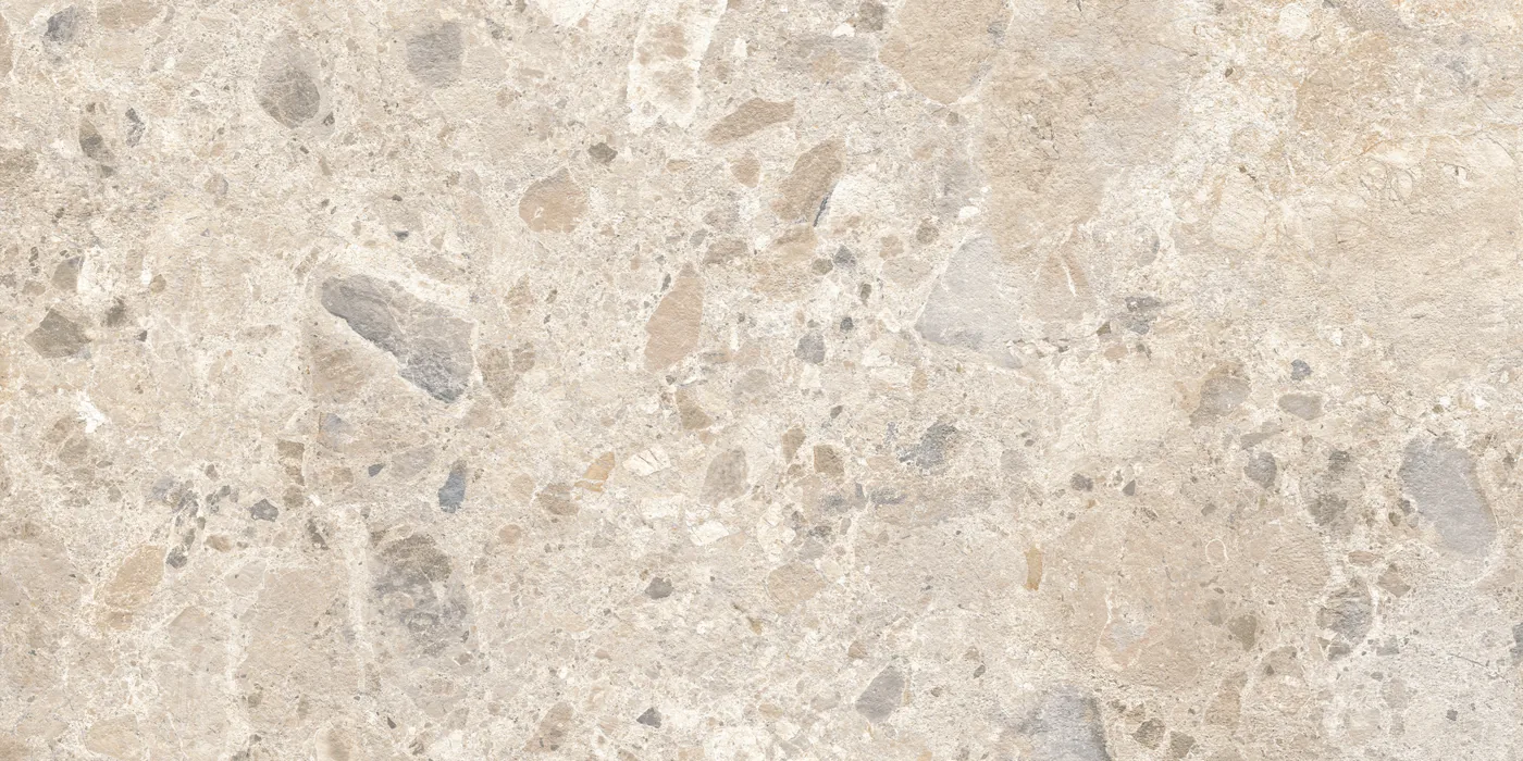 Cremefarbene Fliese 60×120 cm in Terrazzo-Optik mit beigen, grauen und braunen Steinsplittern unterschiedlicher Größe.