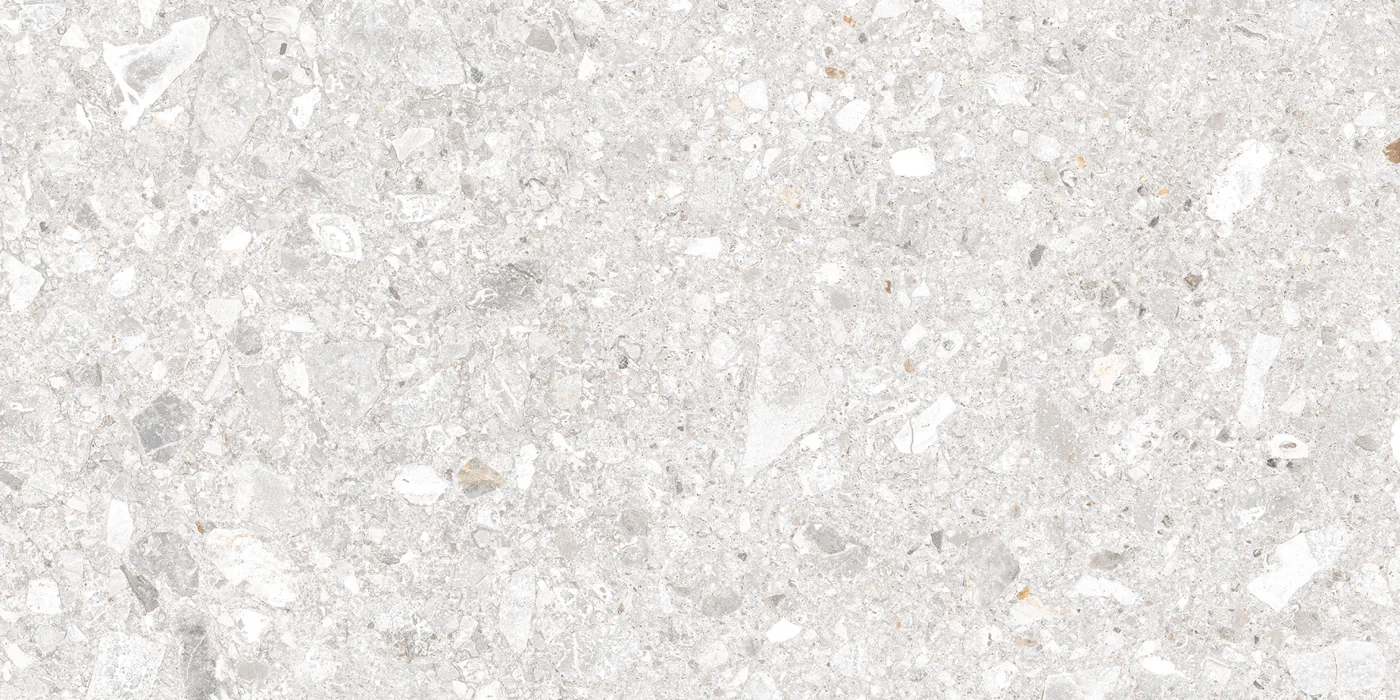 Cremeweiße Fliese in Konglomerat-Steinoptik, 30x60 cm, dicht mit hellen und dunklen Gesteinsbrocken durchsetzt.