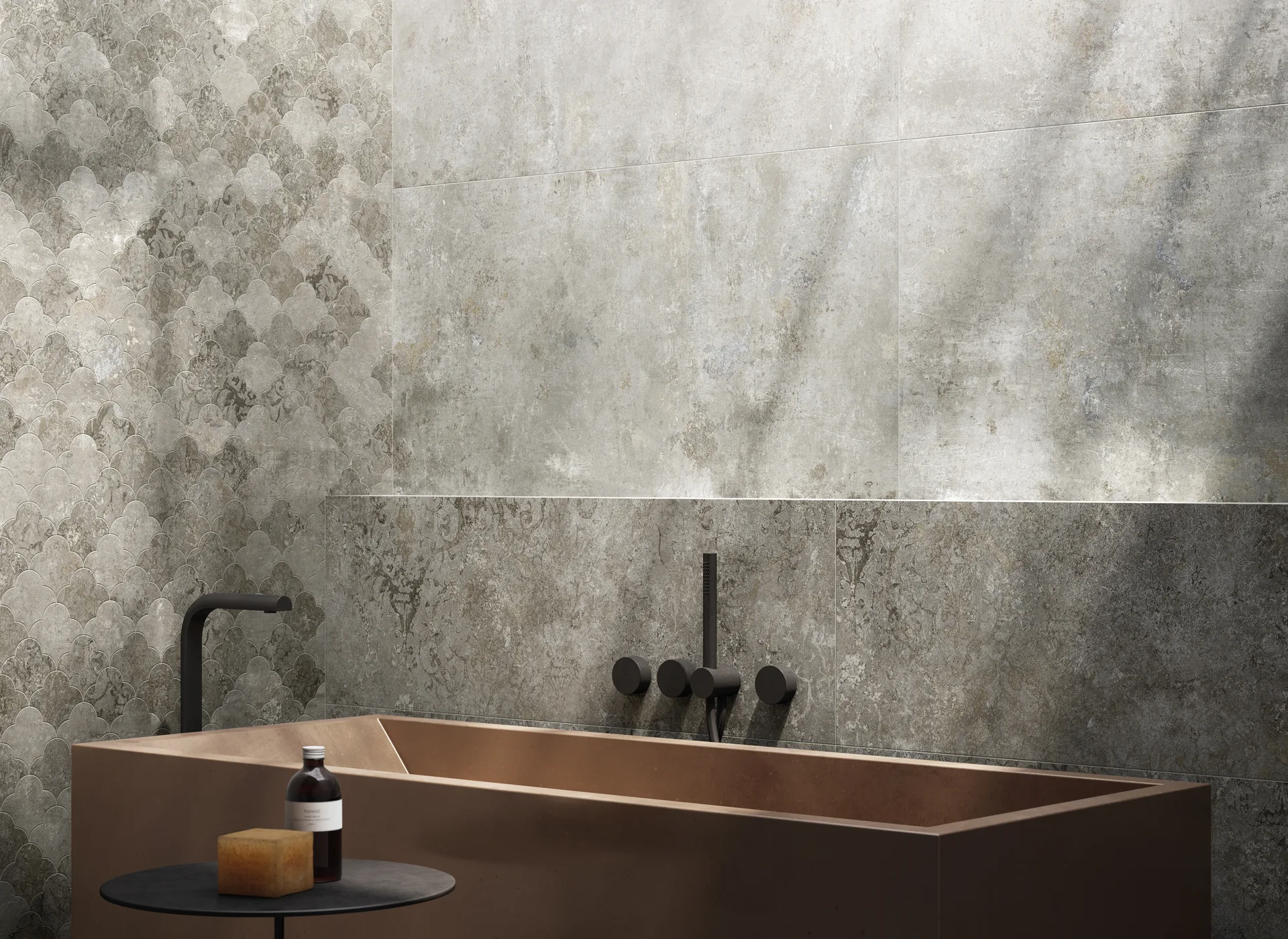 Badausschnitt mit hellgrauer Steinoptik-Wand, Mosaikband und kupferfarbener Wanne, Fliesenformat 60×120 cm.