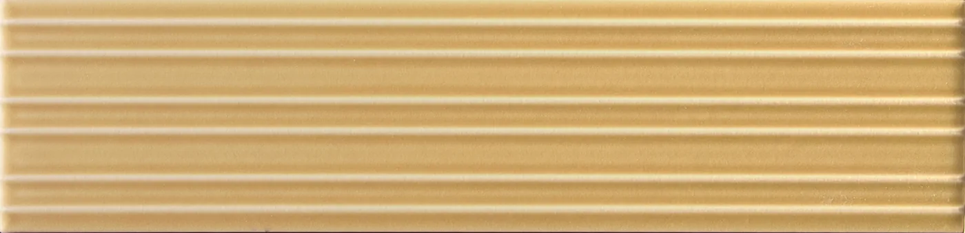 Rechteckige Wandfliese in goldenem Ockerbeige, matt, mit parallelem Rillenrelief, im Format 6x24,6 cm.