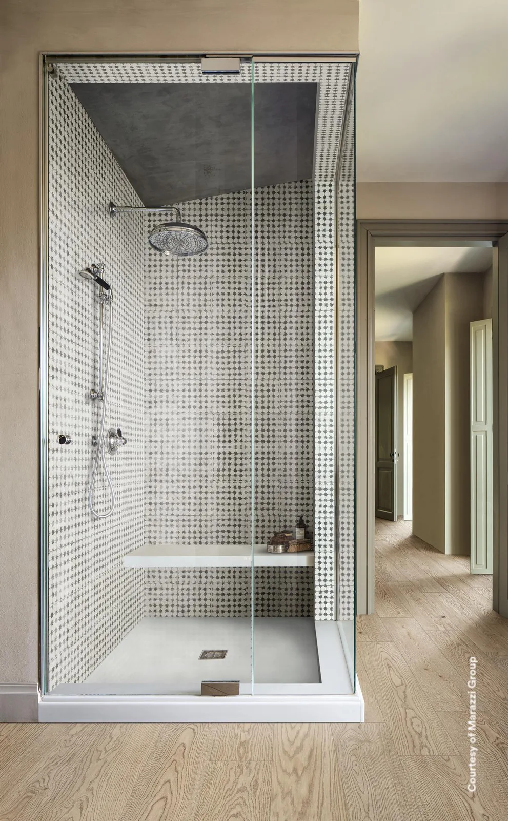 Bad mit bodengleicher Dusche und Mosaikwand, Boden davor in hellbeigen Holzoptik-Planken verlegt.