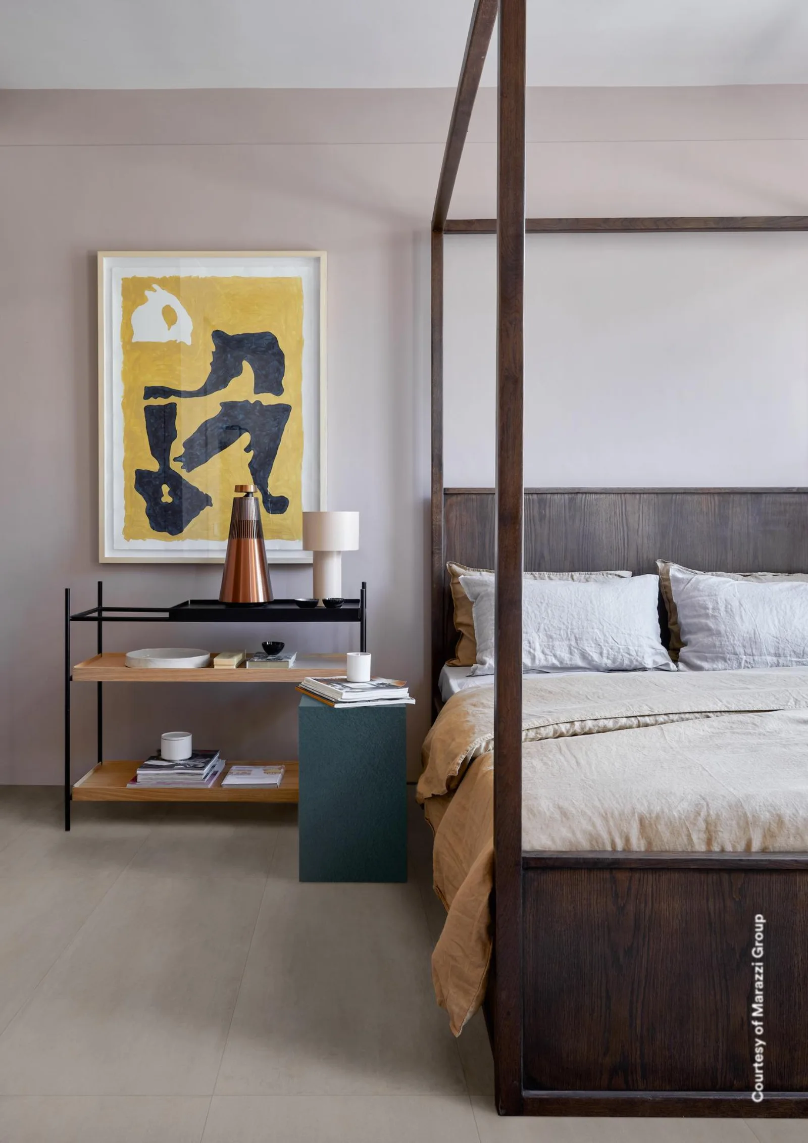 Schlafzimmer mit Himmelbett und gelbem Wandbild, beigegrauer Betonoptik-Boden und Wände im gleichen Ton.