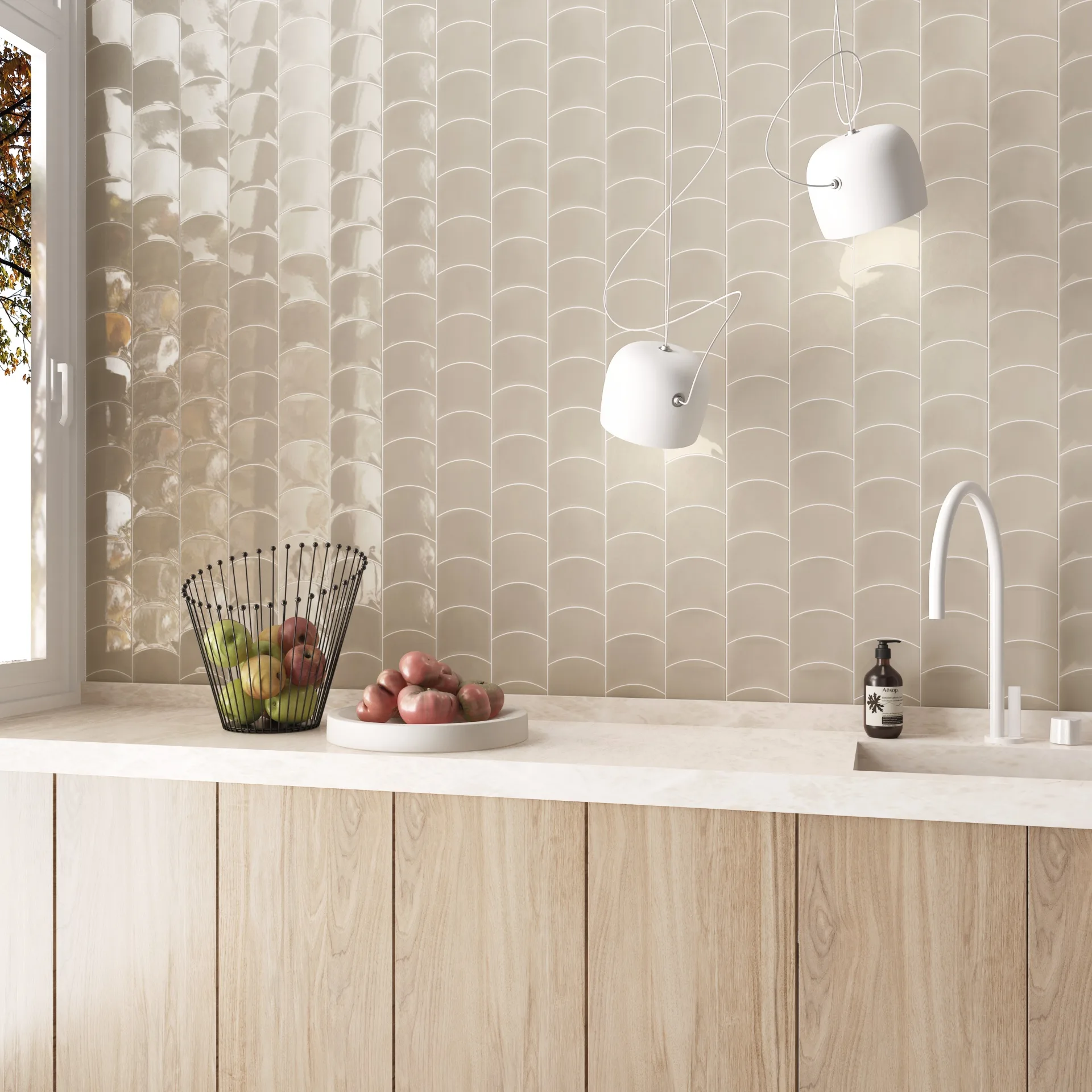 Küche mit cremefarbener Wellenfliesenwand, heller Holzfront, Obstschale und weißen Pendelleuchten.