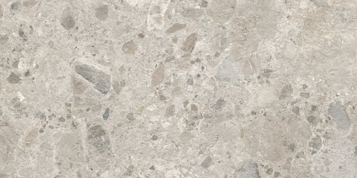 Graue Fliese 60×120 cm in Terrazzo-Optik mit hellen und dunkelgrauen Steinsplittern unterschiedlicher Größe.