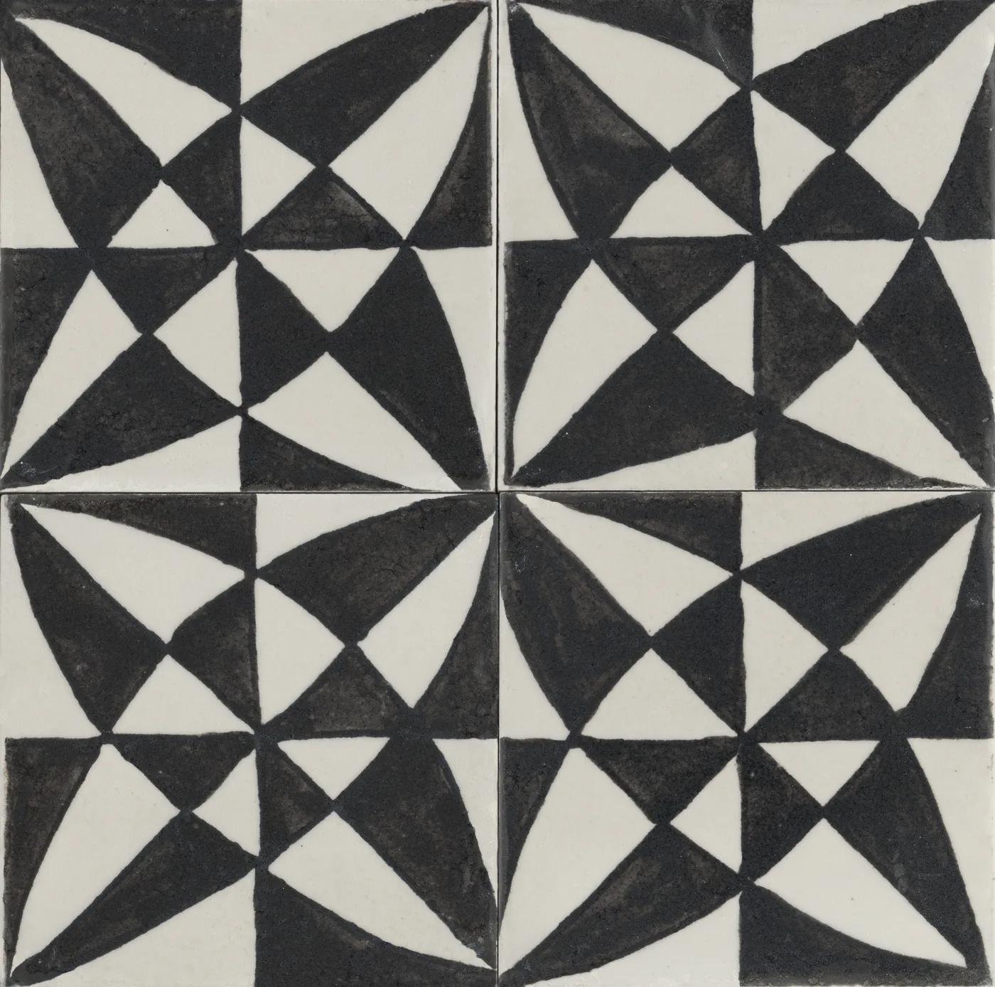Vier glänzende Fliesen 15x15 cm mit geometrischem Dreiecksmuster in Schwarz und Weiß, zusammen ein Windradstern.