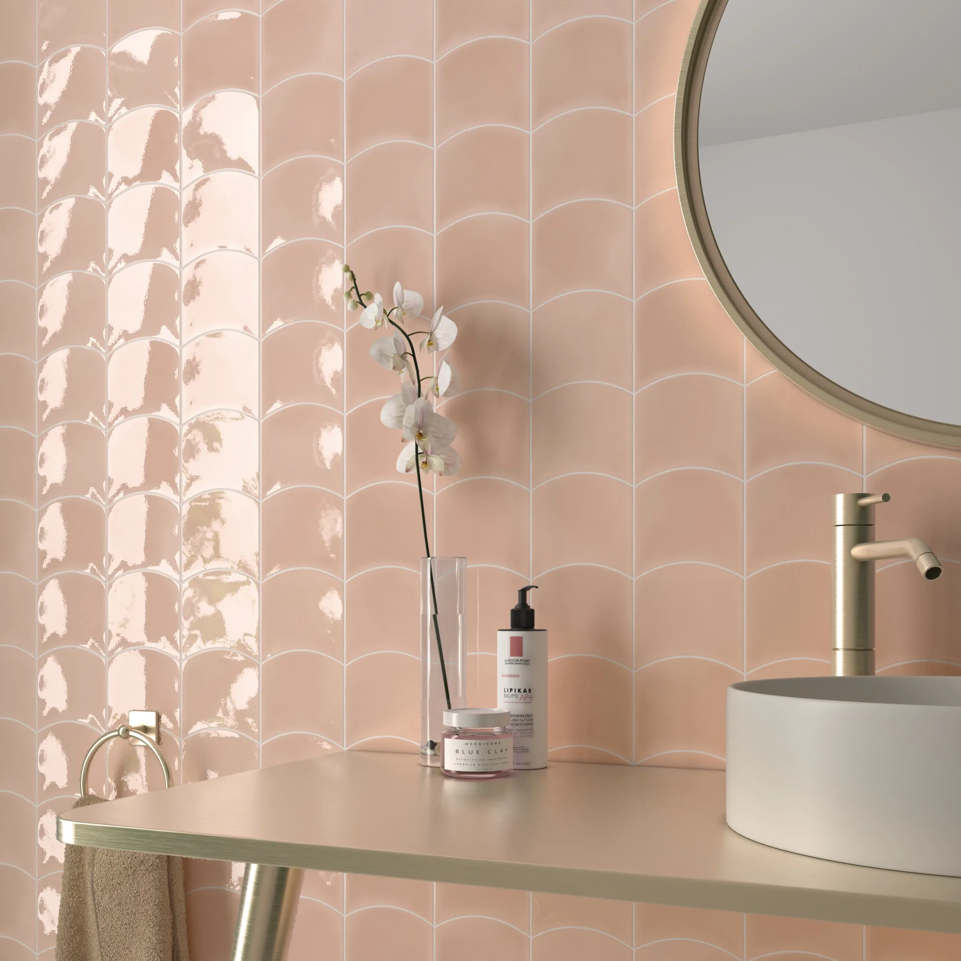 Bad mit roséfarbener Wellenfliesenwand, rundem Goldrahmenspiegel, Orchidee und weißem Aufsatzbecken.