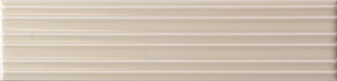 Rechteckige Wandfliese in hellem Greige-Taupe, glänzend, mit parallelem Rillenrelief, im Format 6x24,6 cm.