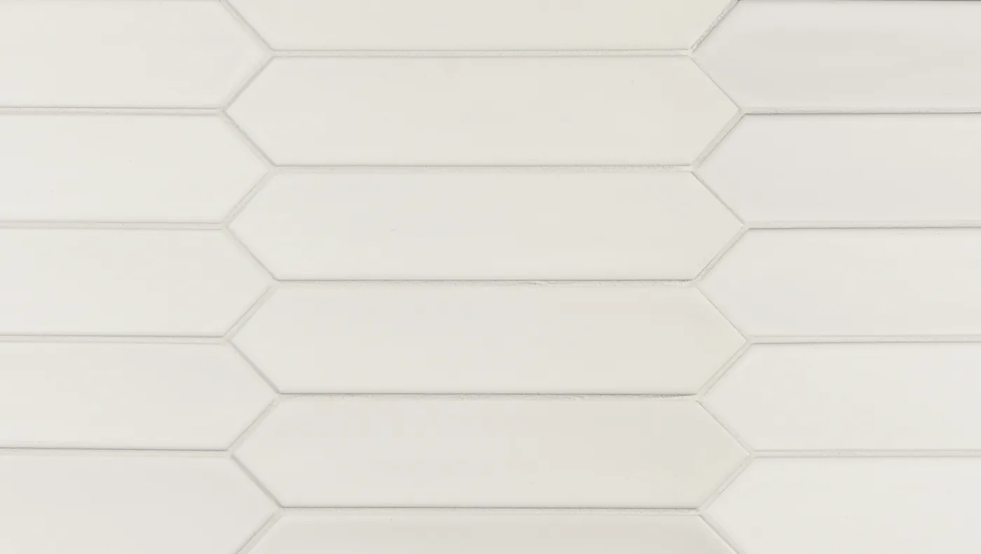 Weiße, spitz zulaufende Wandfliese im Format 5×25 cm, matt glasiert mit sanftem Glanz und leichter Farbschattierung.