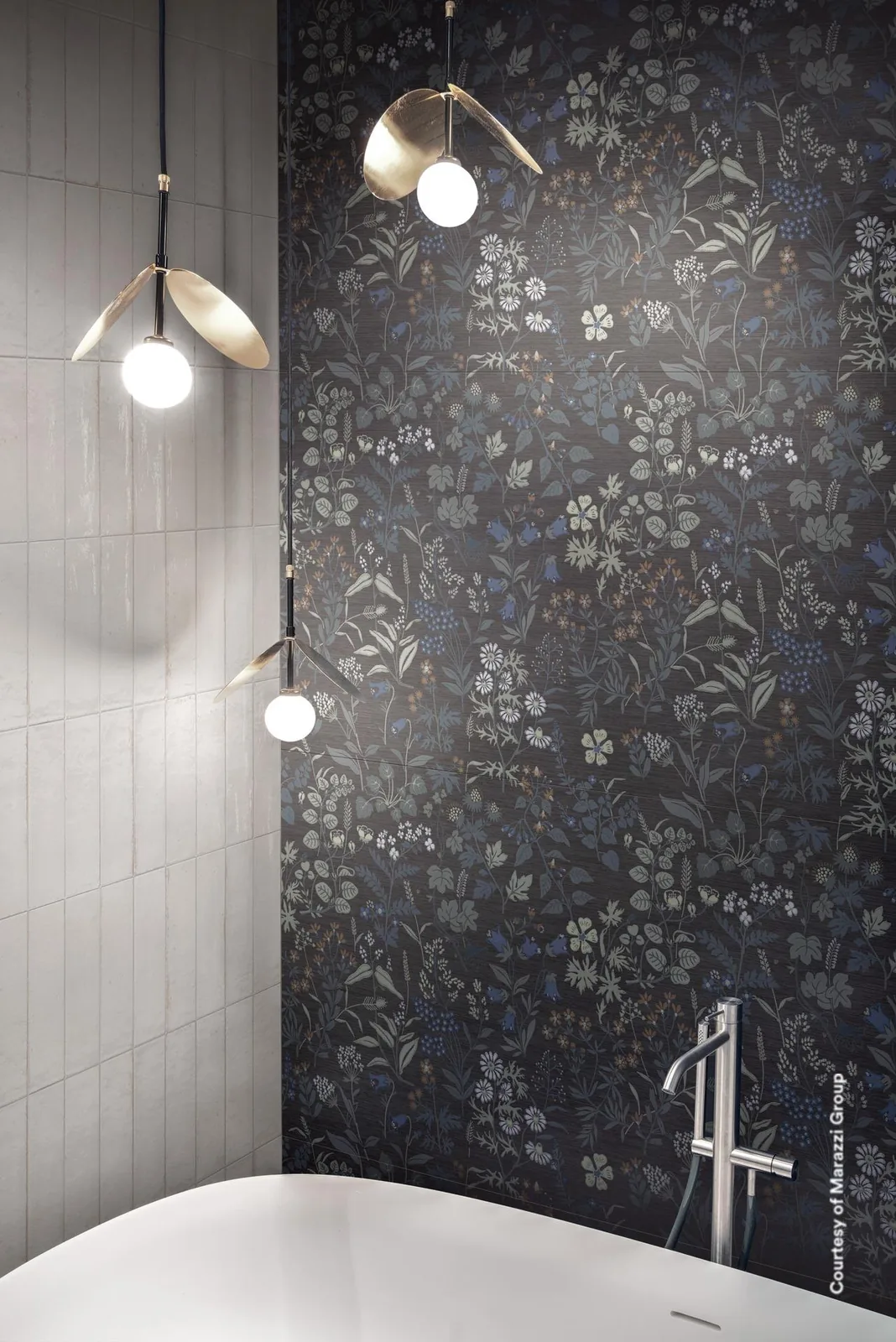 Bad mit dunkler Wiesenblumen-Dekorwand hinter freistehender Wanne, links eine Wand aus kleinen weißen Glanzfliesen.