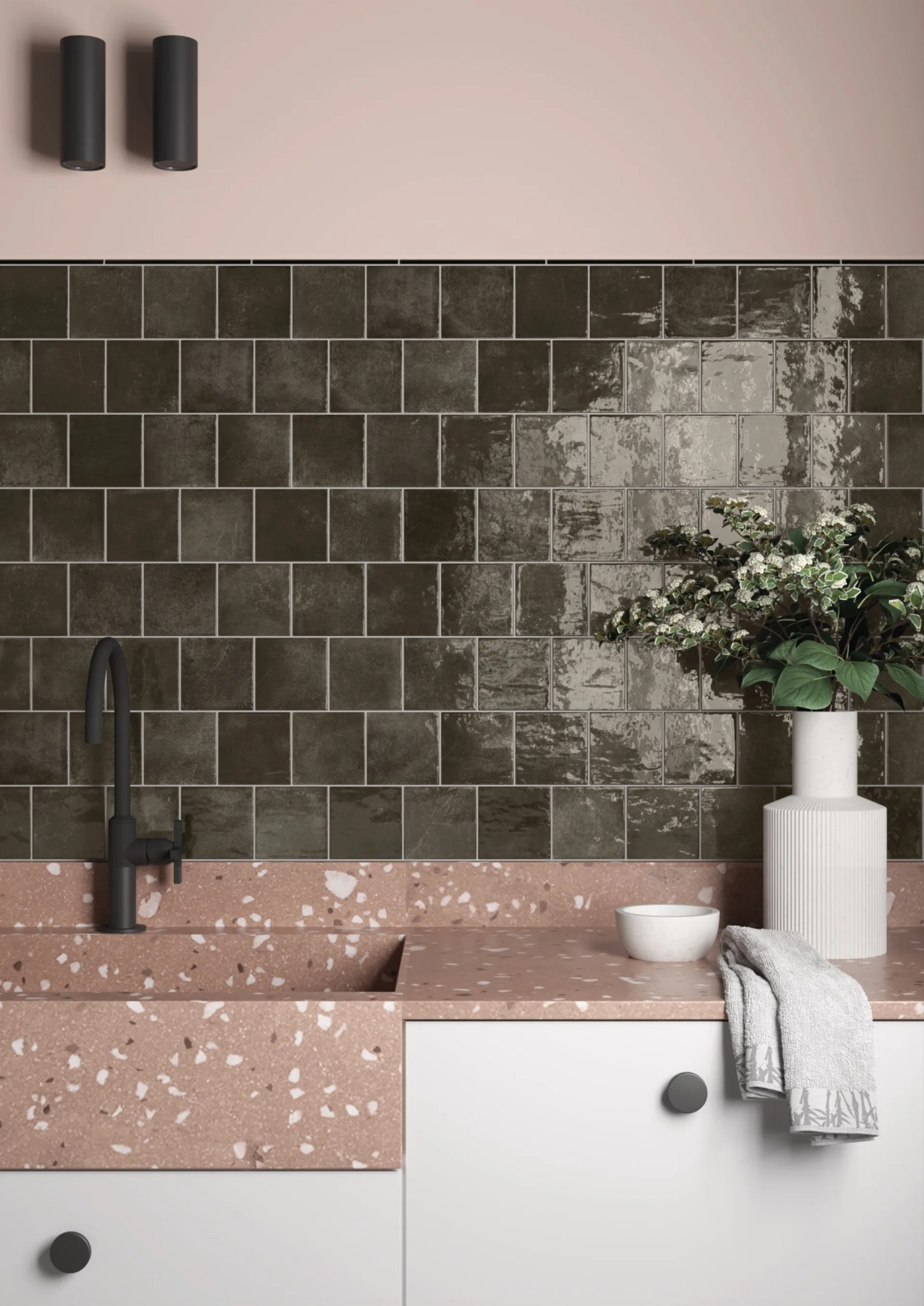 Küche mit dunkelgrün glänzenden Quadratfliesen, rosa Terrazzo-Arbeitsplatte und schwarzer Armatur.